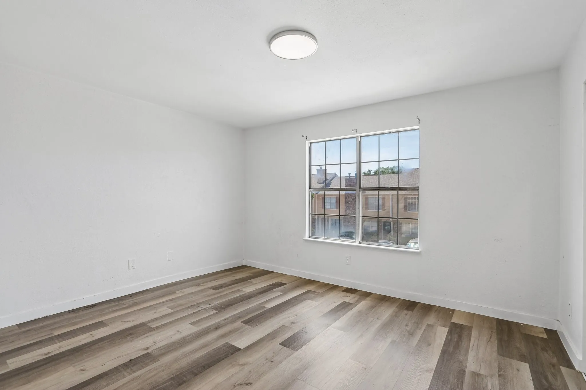 Neutral white walls complement the wood-finish flooring