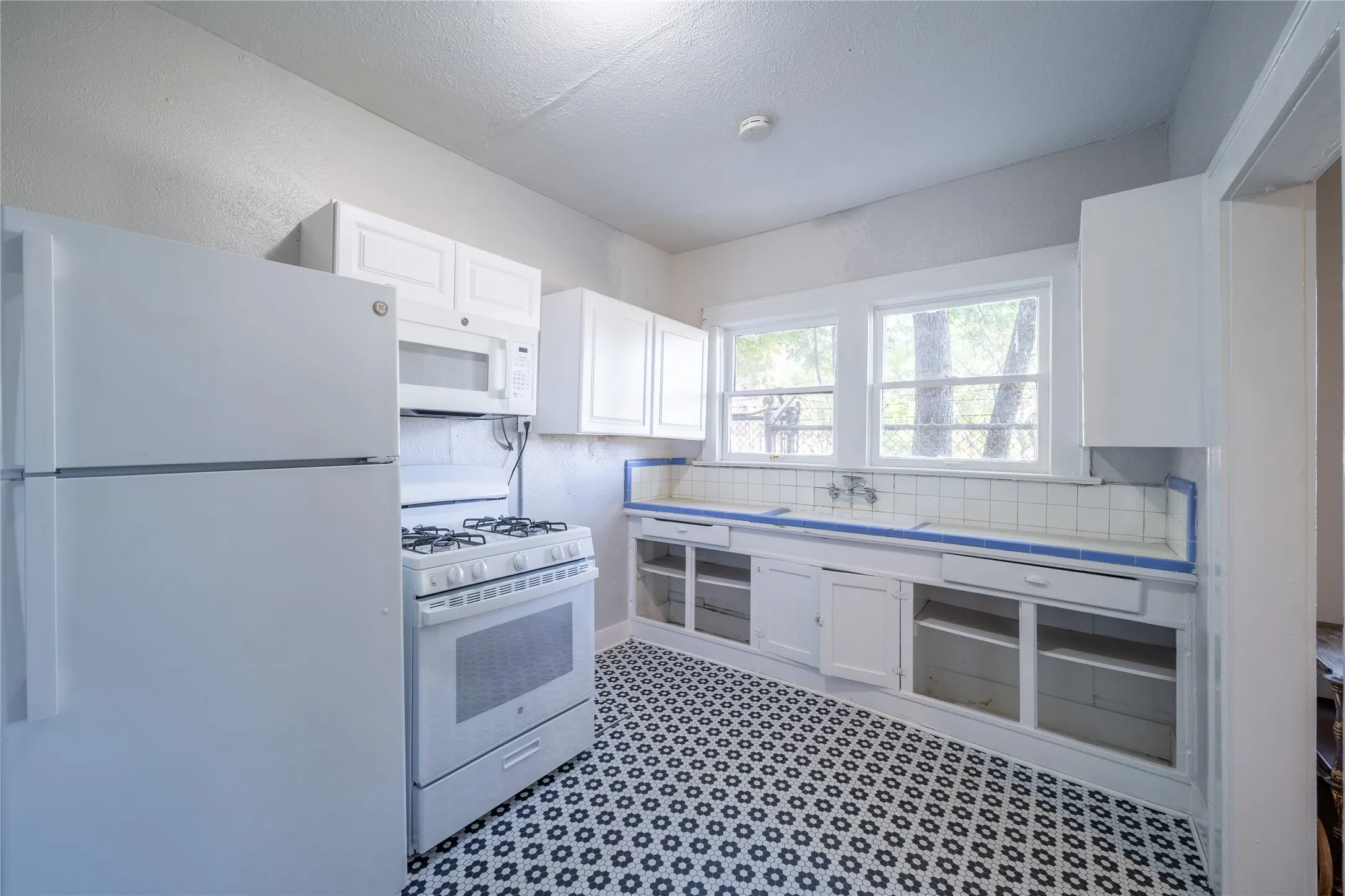 909 Sunset - The updated kitchen features gas burning stove, refrigerator and updated flooring.