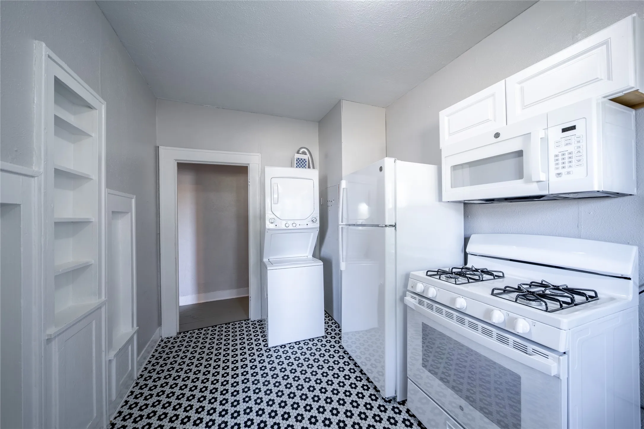 909 Sunset - The kitchen features built-in wall storage and is also where the washer and dryer are located.