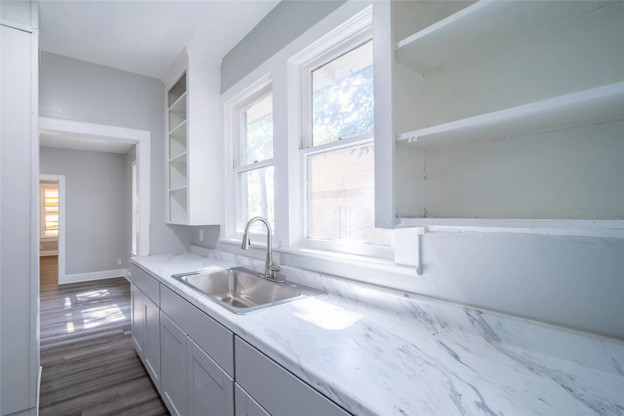 923 Sunset. The newly remodeled kitchen features open upper cabinets and a galley style kitchen.
