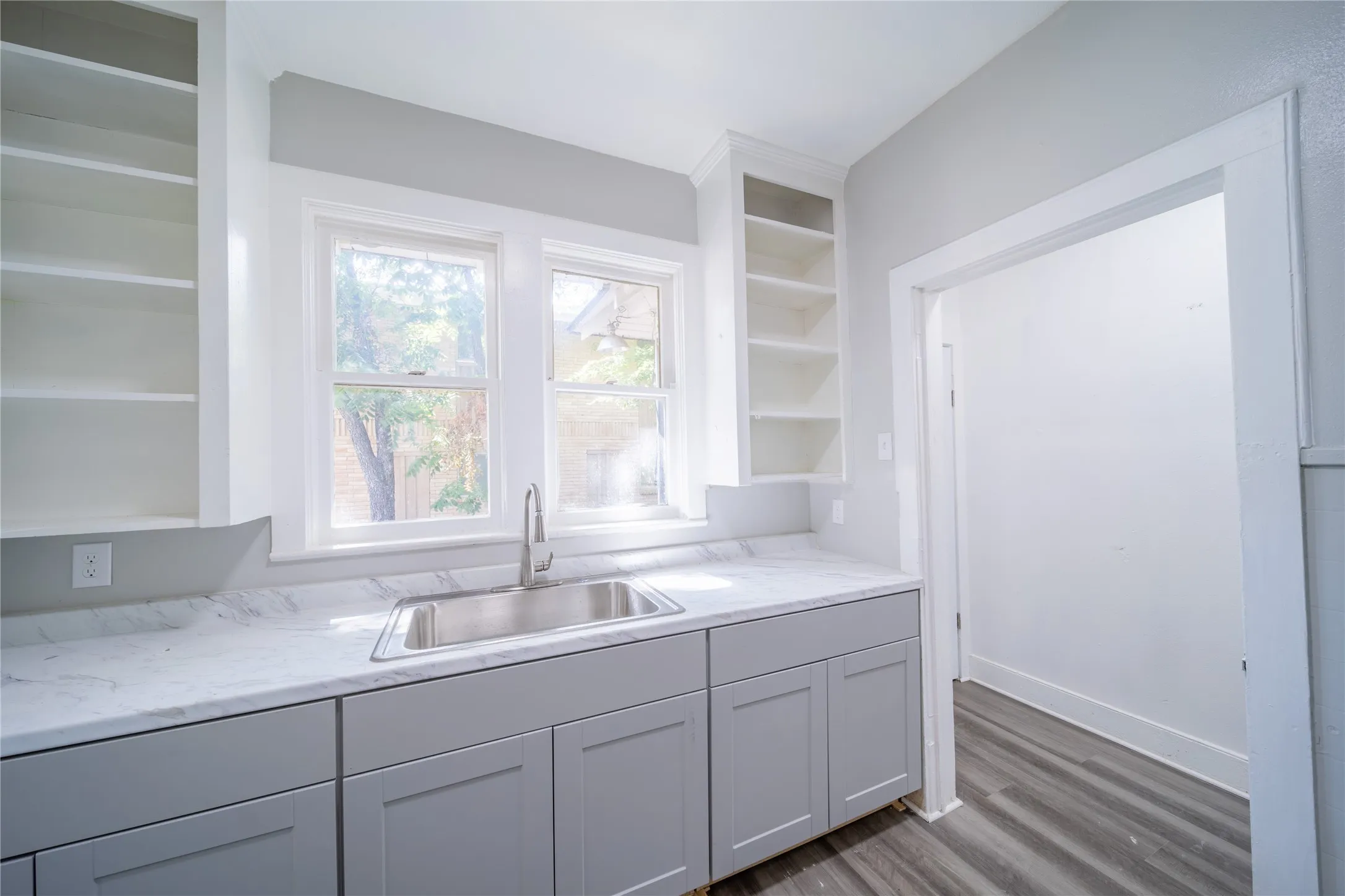923 Sunset. The kitchen features updated cabinets and the door in the photo leads to the utility room with space for stackable washer and dryer.