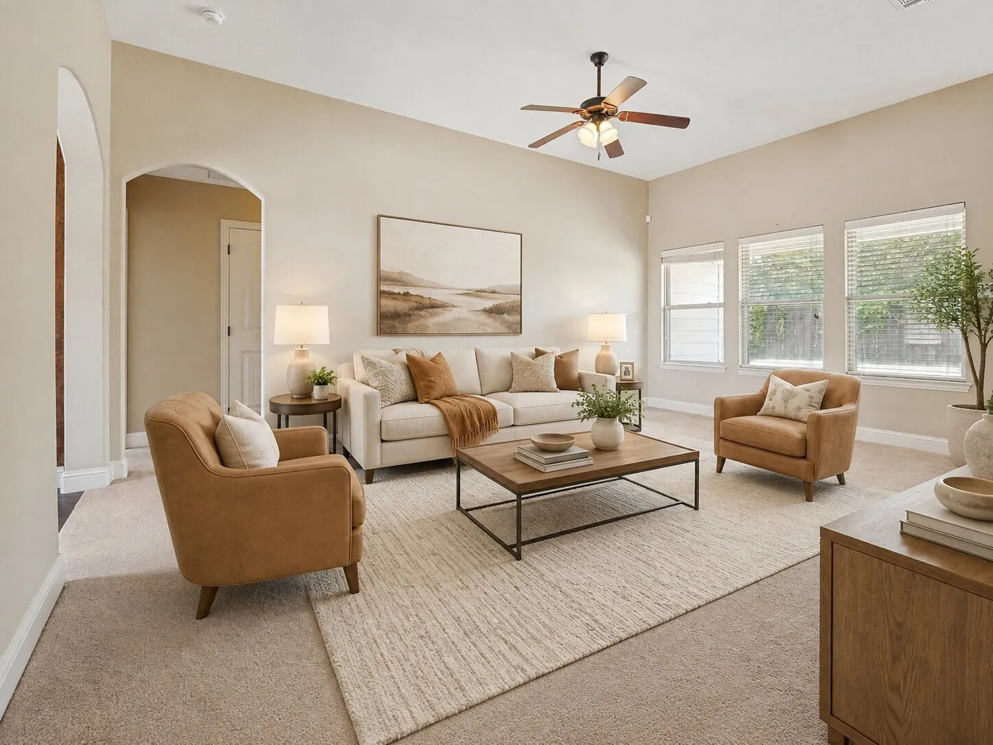 Spacious living area featuring high ceilings, a ceiling fan with integrated lighting, and multiple windows with blinds