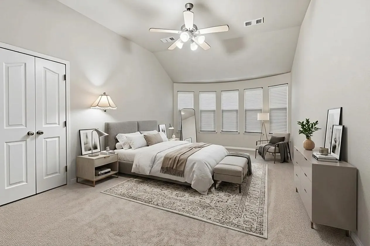 Vaulted ceiling bedroom featuring carpeting, a ceiling fan with integrated lighting, and a prominent bay window