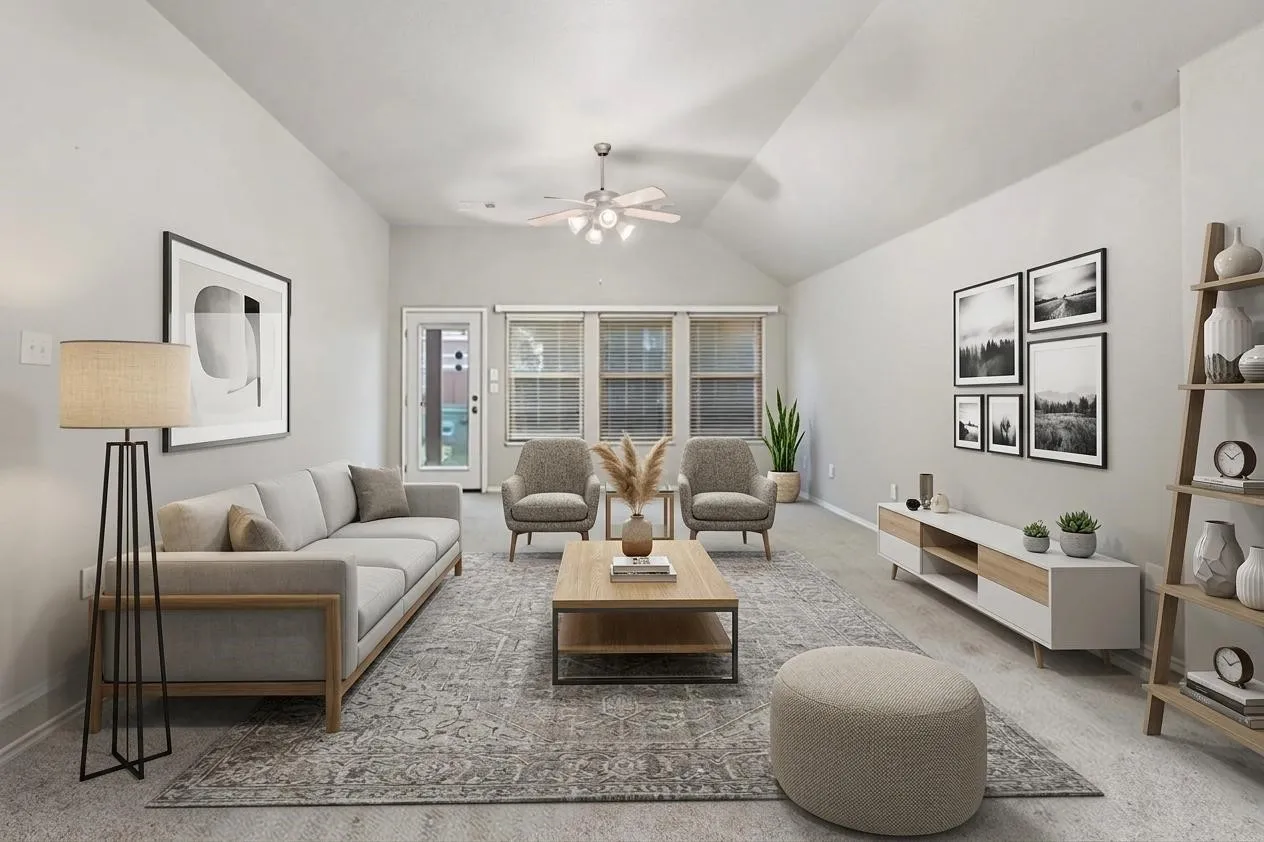 Vaulted ceilings enhance this living area featuring light gray walls and carpet flooring