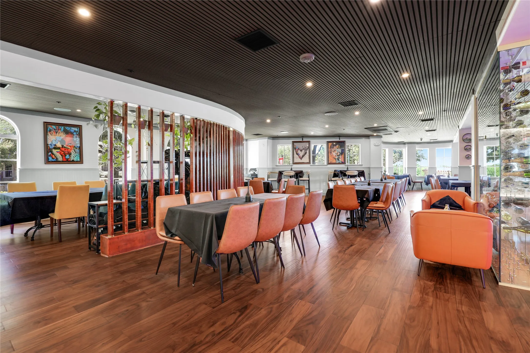 Spacious interior featuring wood-finish flooring, a slatted wood room divider, recessed lighting, and a dark paneled ceiling