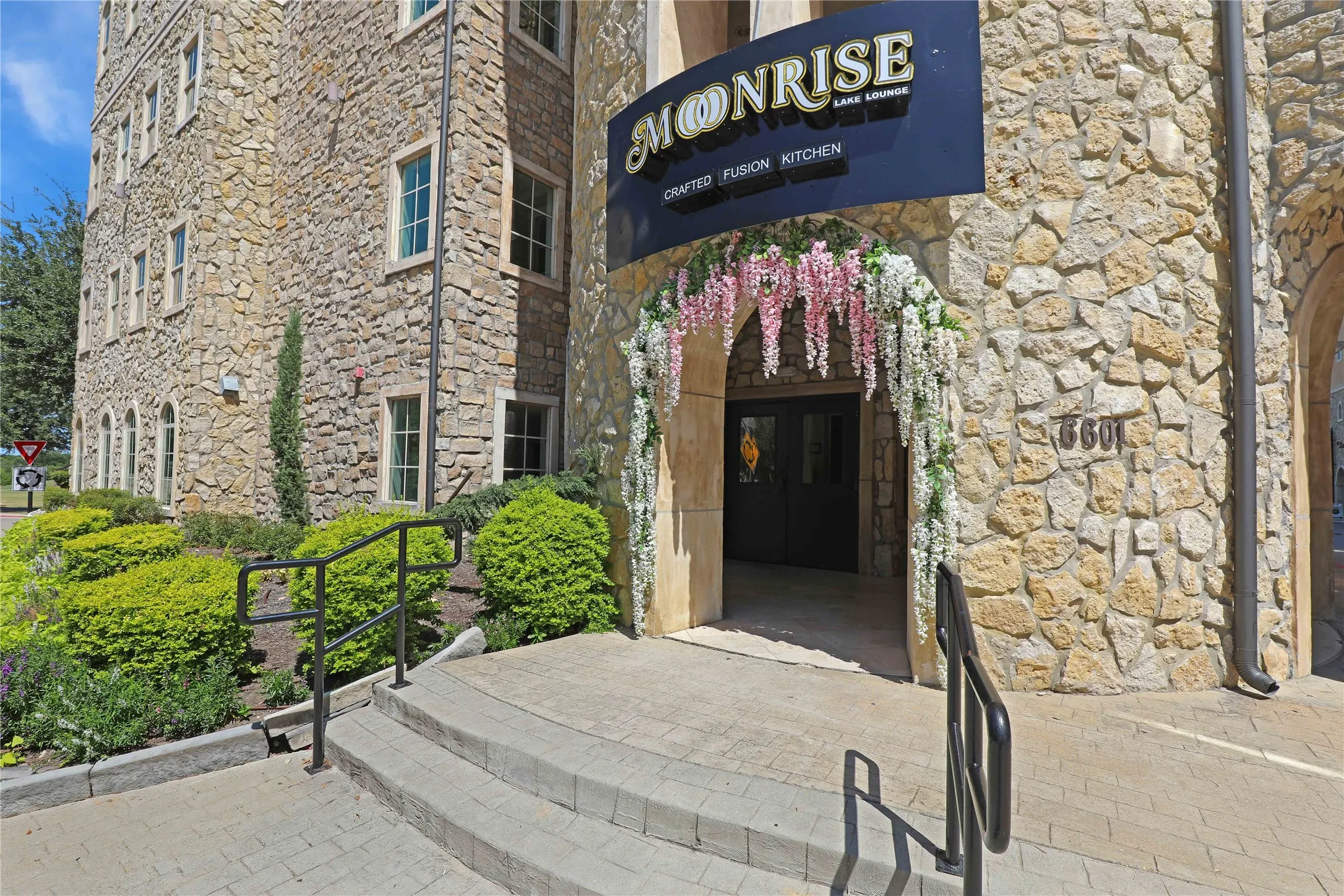 Stone veneer exterior featuring multiple windows with trim