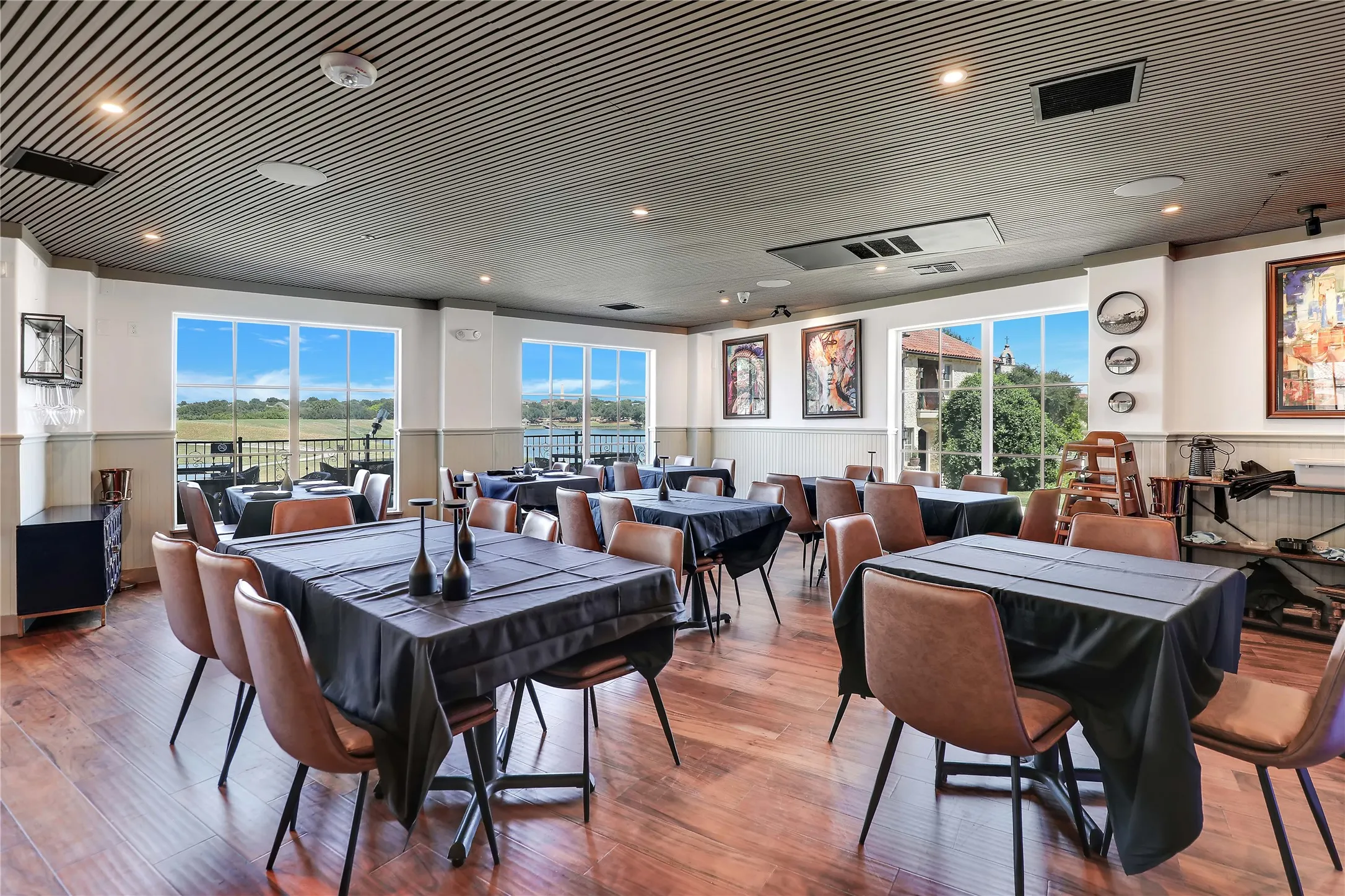Spacious interior featuring wood-finish flooring, a slatted ceiling, and multiple large windows