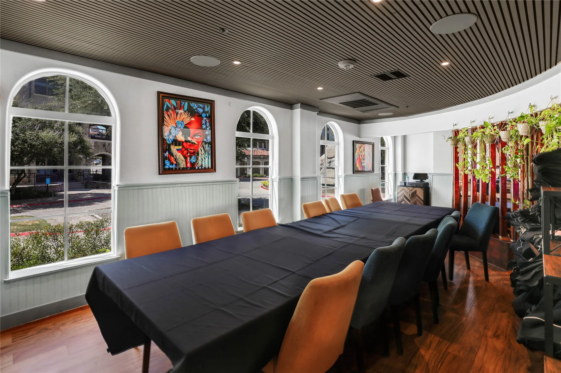 Spacious room with arched windows, wood-finish flooring, recessed lighting, and a slatted ceiling