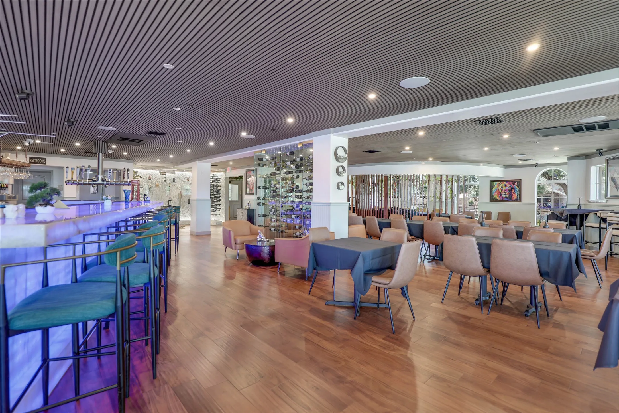 Open-plan commercial interior featuring wood-finish flooring and a slatted ceiling