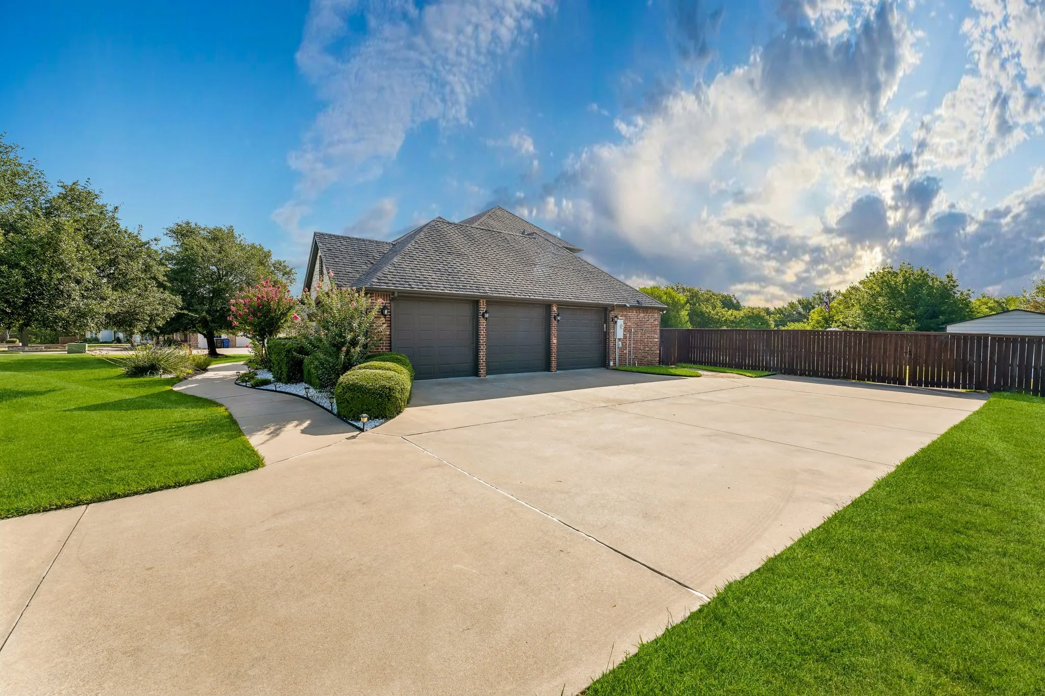 Driveway with 3 car attached garage and access to the workshop through the gate.
