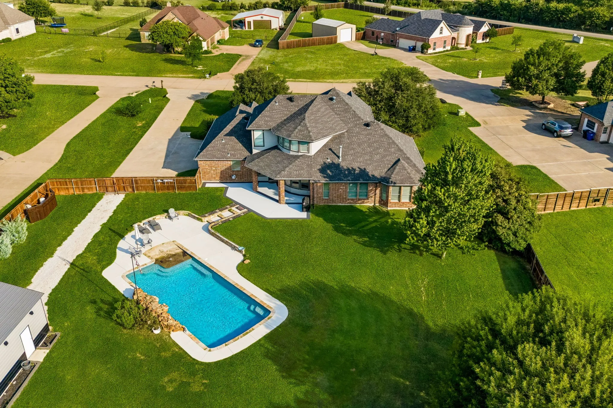 Back of home with pool and large backyard.