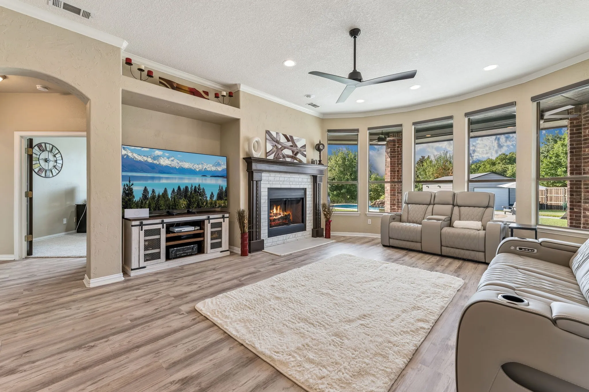 First floor living room with view of back yard and hallway to primary bedroom and office