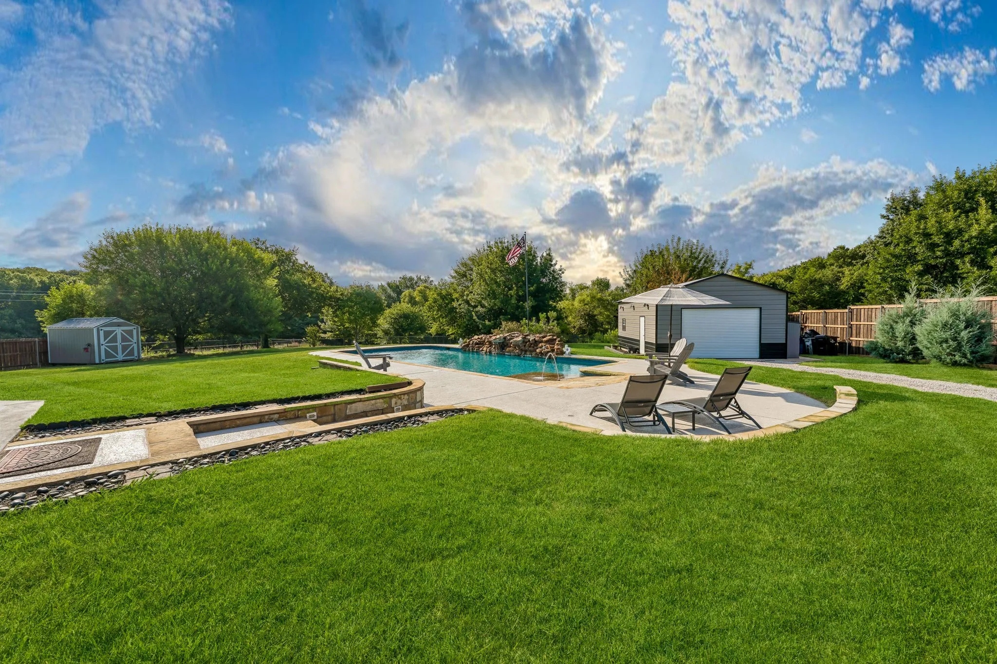 View of large backyard. pool, workshop, and storage shed.