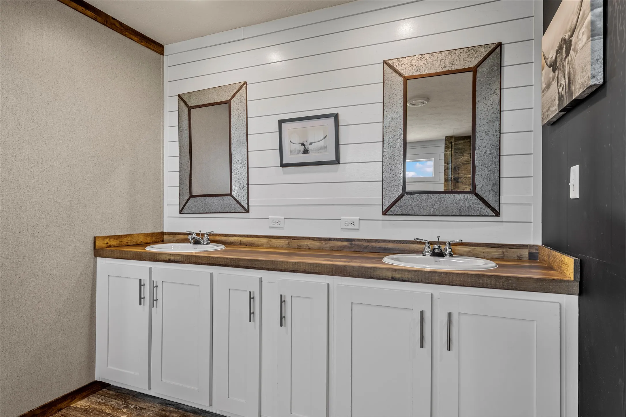 Dual rectangular mirrors above a double vanity featuring white cabinetry