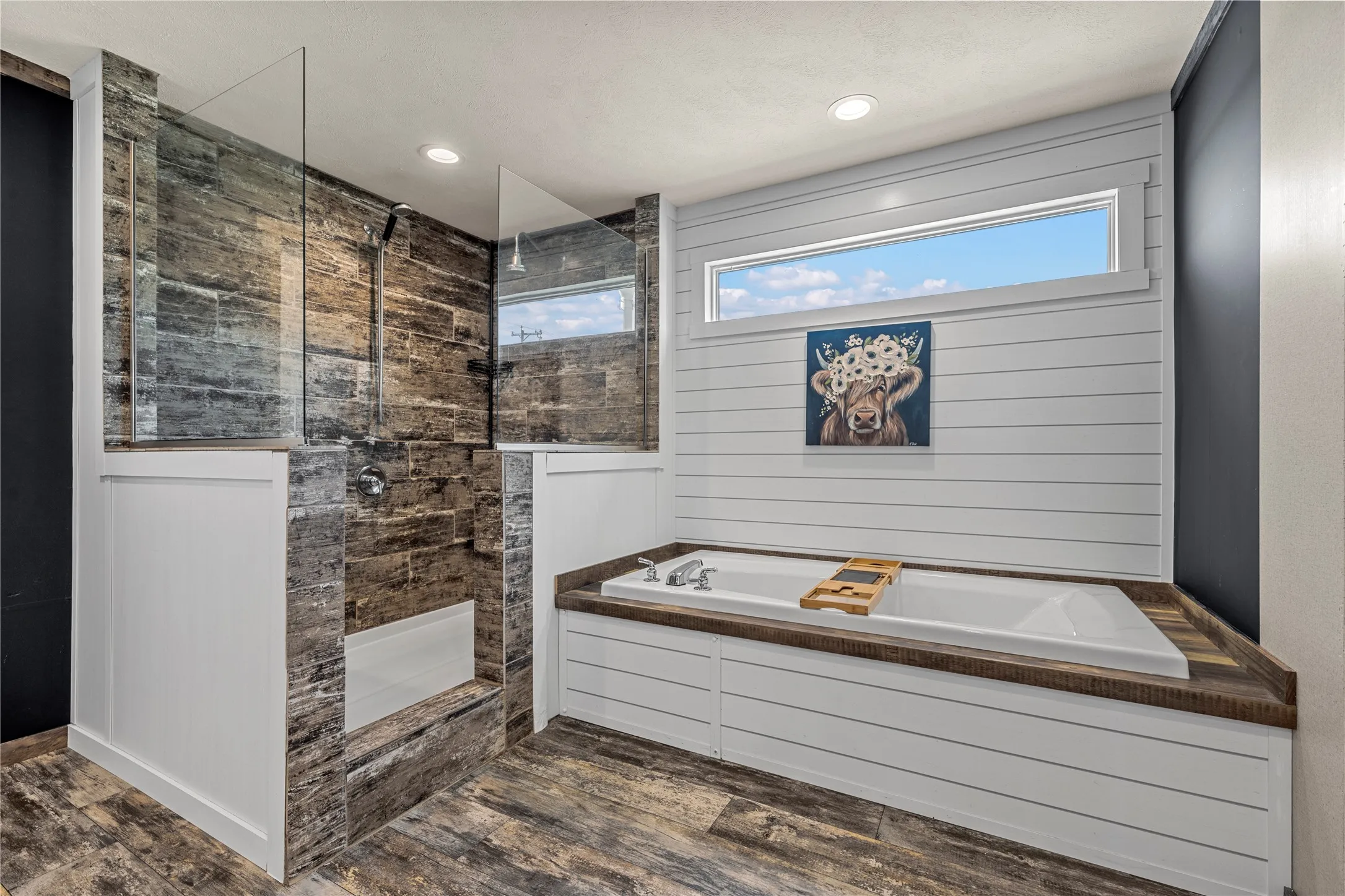 Spacious bathroom featuring a walk-in shower with stone-look tile, clear glass partitions, and a built-in bench