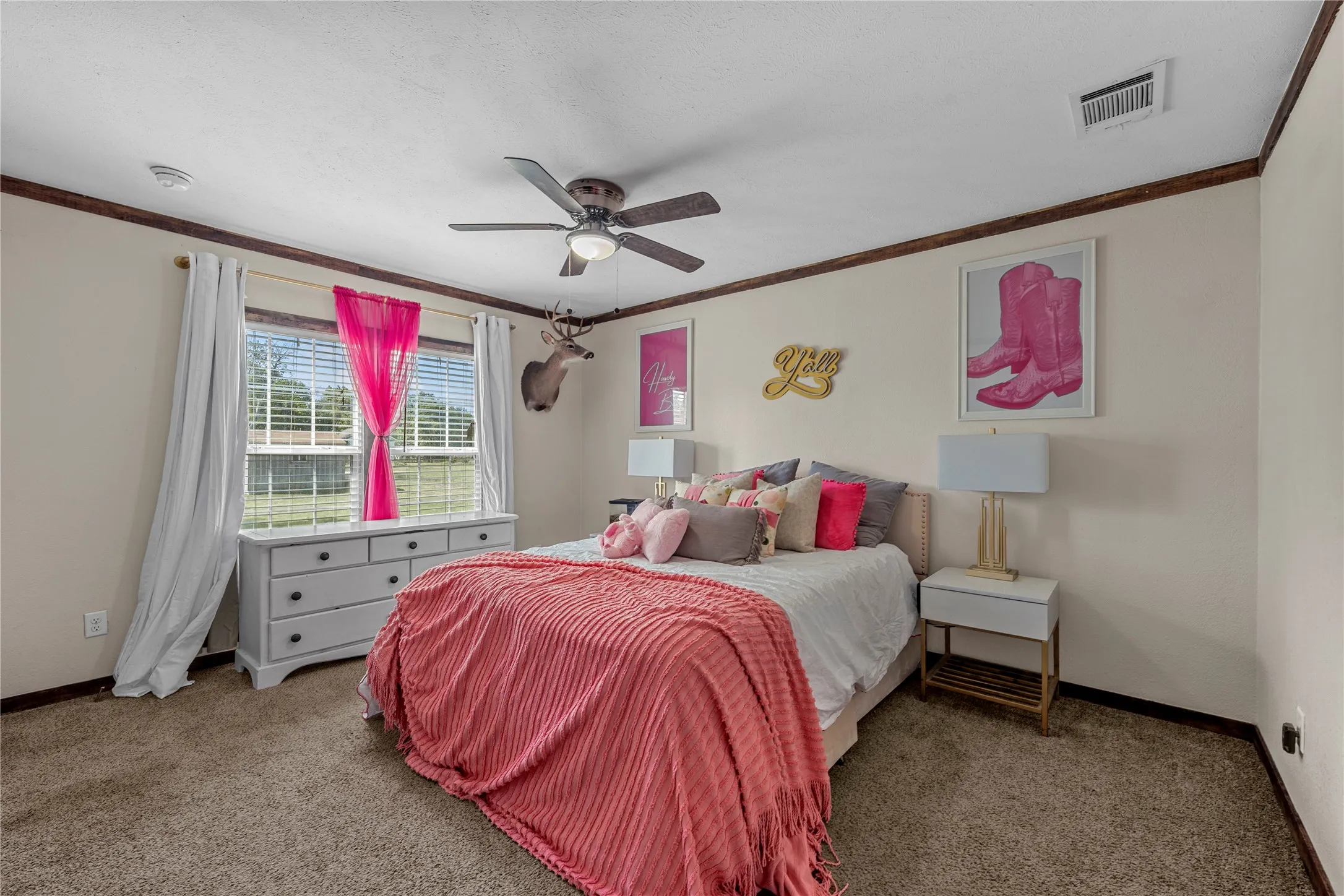 Carpeted room featuring a ceiling fan with integrated lighting, a window with horizontal blinds, and dark wood trim