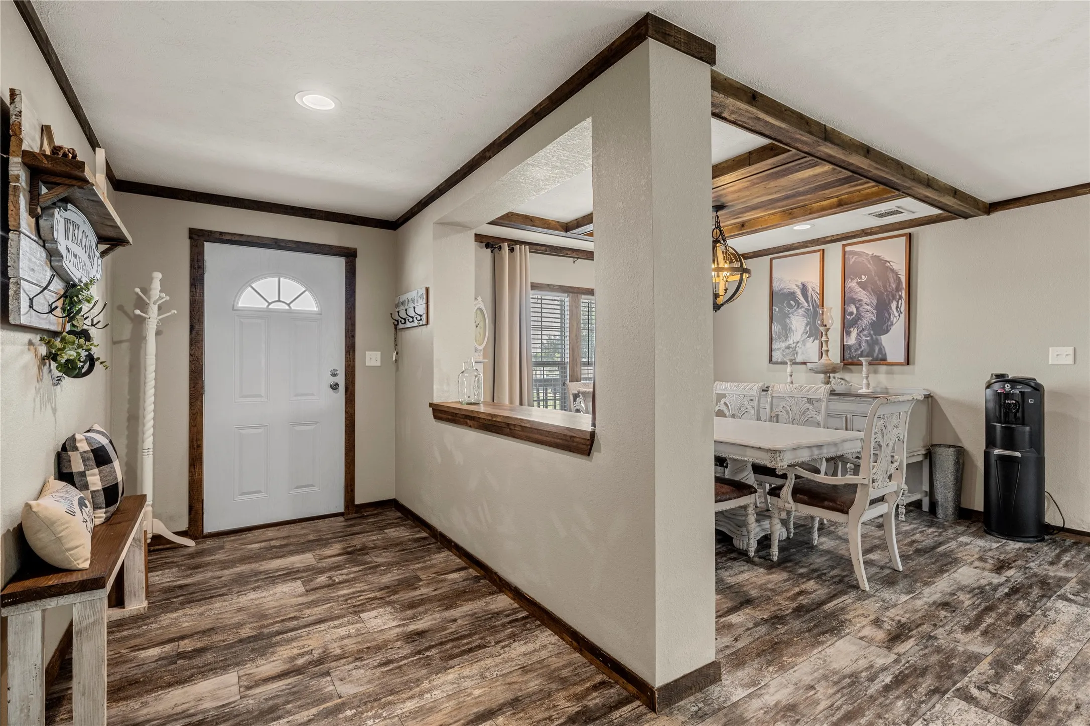 Entryway featuring wood-finish flooring, a white paneled door with an arched window, recessed lighting, and dark wood trim