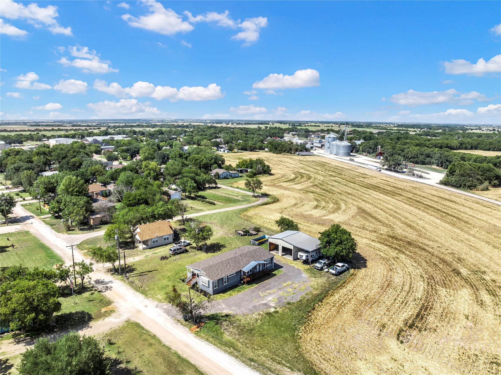 Aerial perspective showcasing a single-story residence with a light-colored exterior and a covered front porch