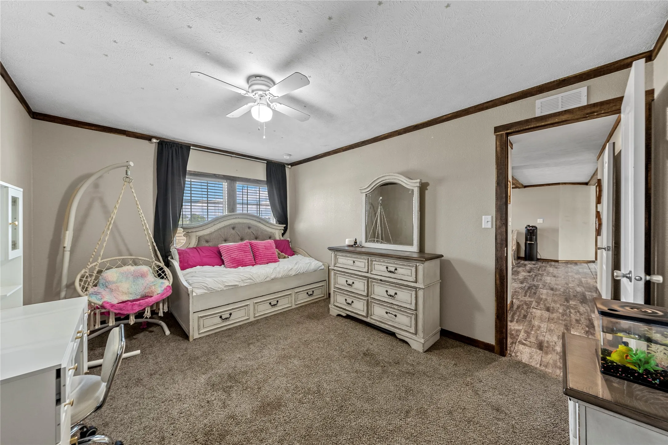 Neutral-toned room featuring a window with blinds, dark valances, and a ceiling fan with integrated lighting