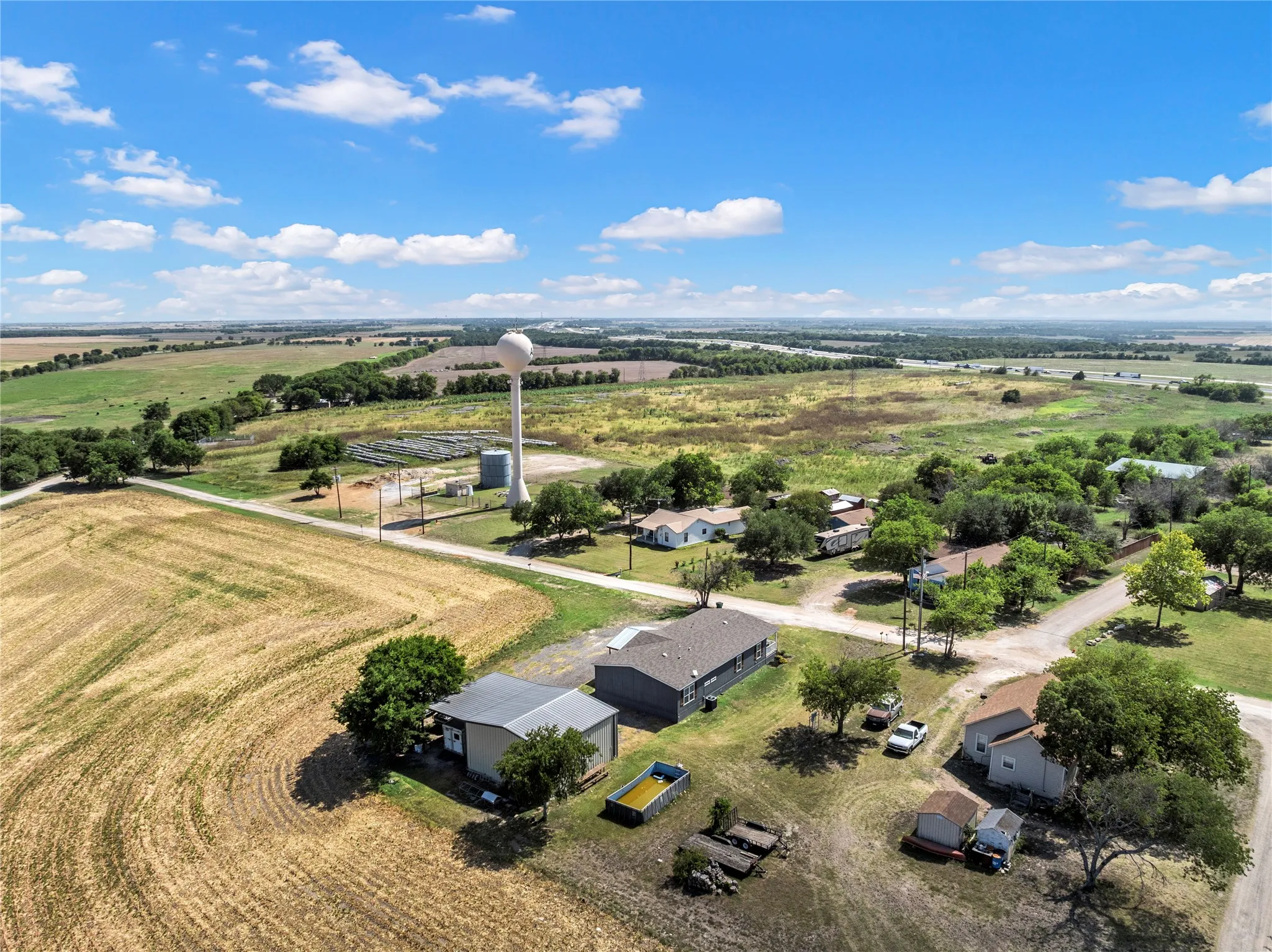 Aerial perspective showcasing expansive rural landscape with agricultural fields and scattered residential properties