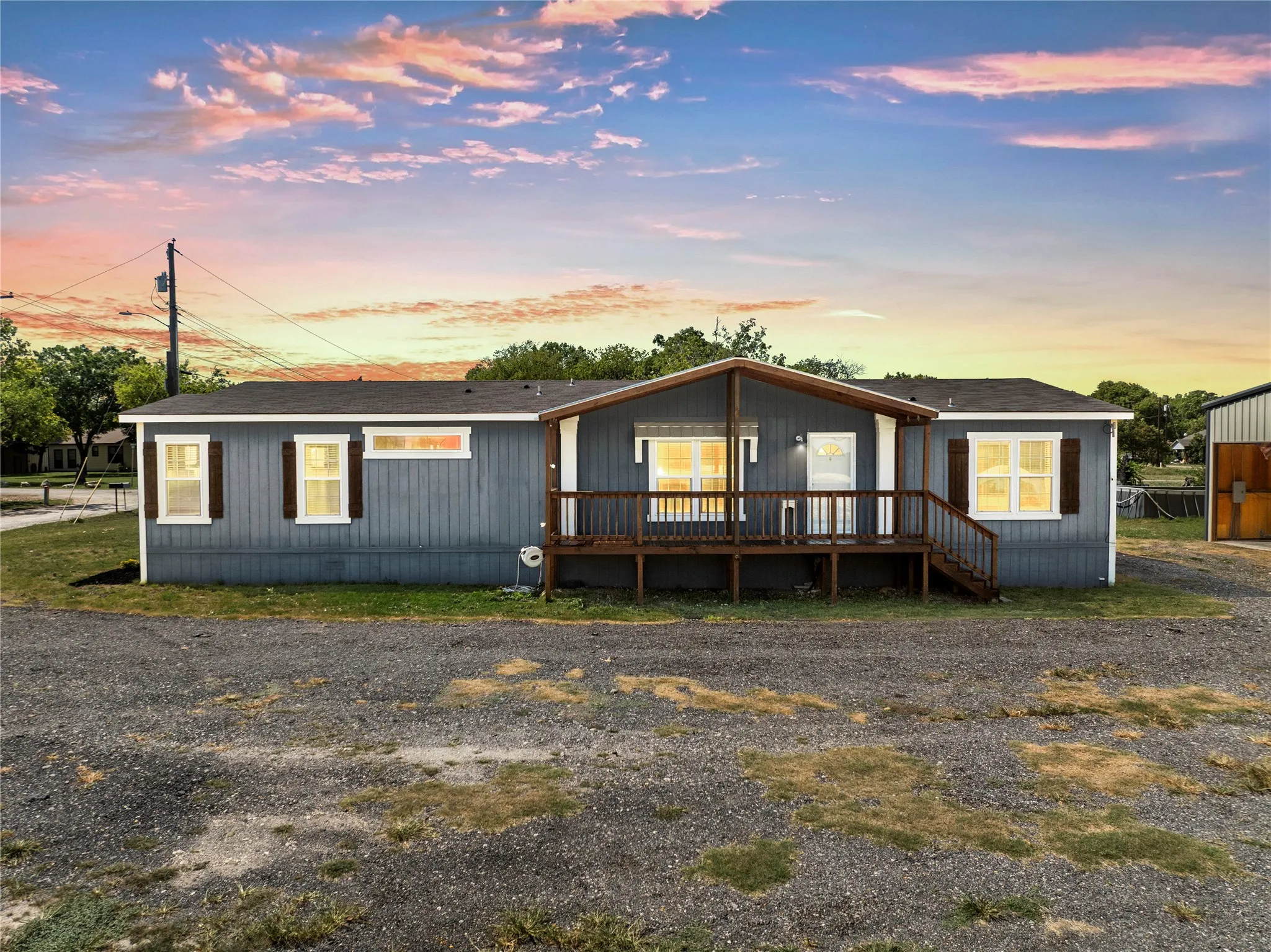 Blue horizontal siding exterior with white window trim and decorative wood shutters