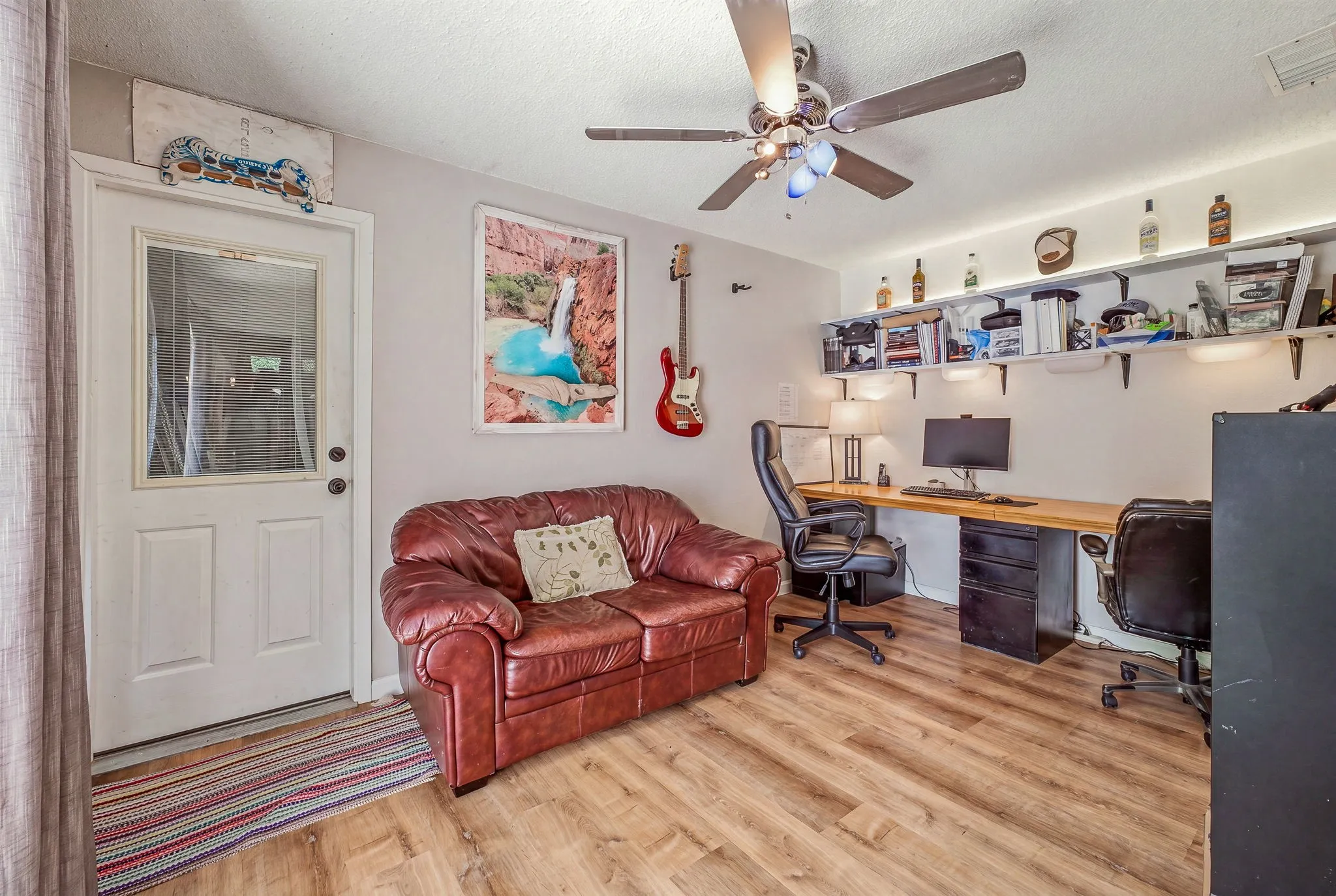 Versatile room featuring wood-finish flooring and a ceiling fan with integrated lighting
