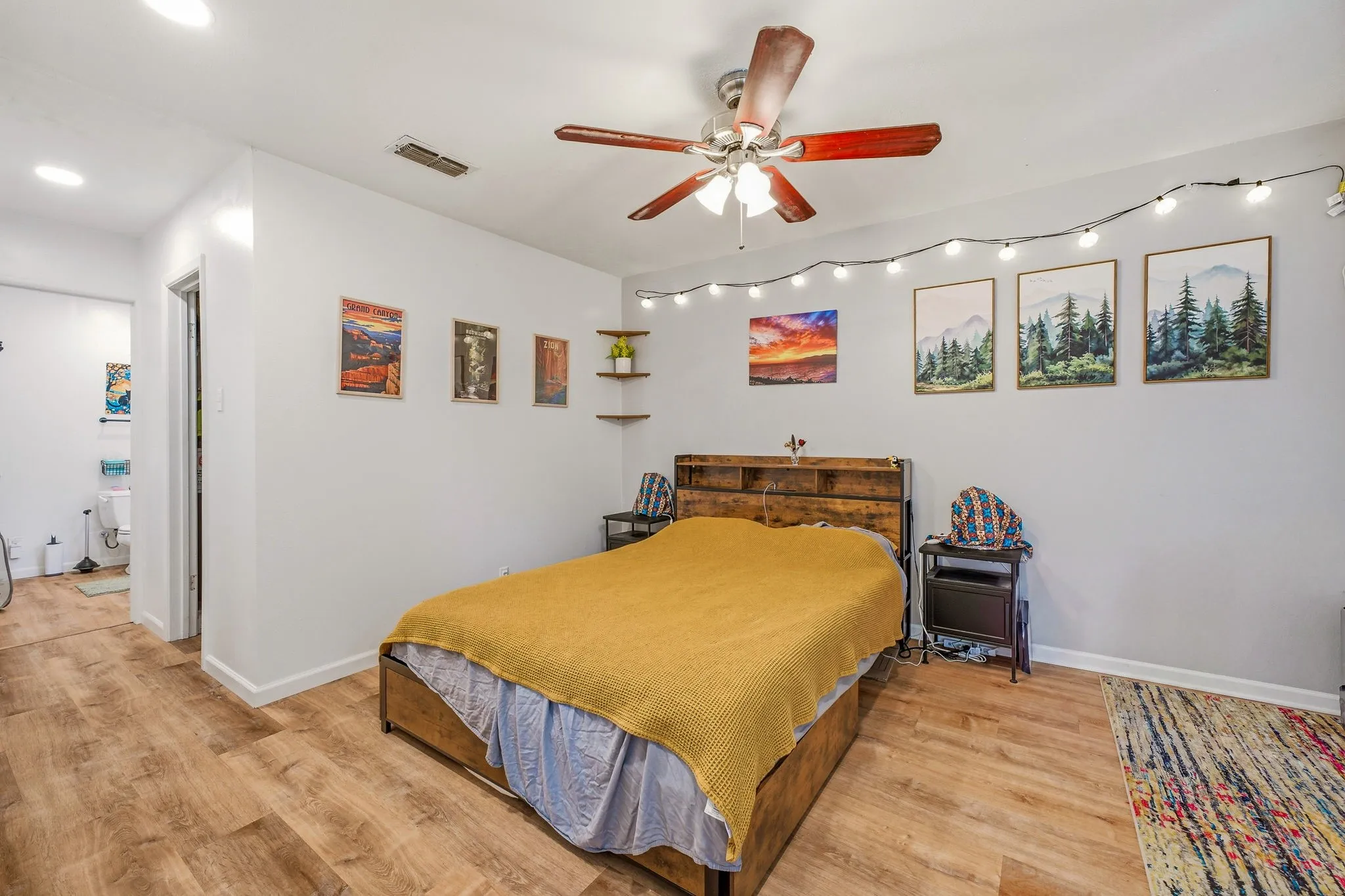 Bedroom featuring wood-finish flooring, a ceiling fan with integrated lighting, recessed lighting, and a white interior wall finish