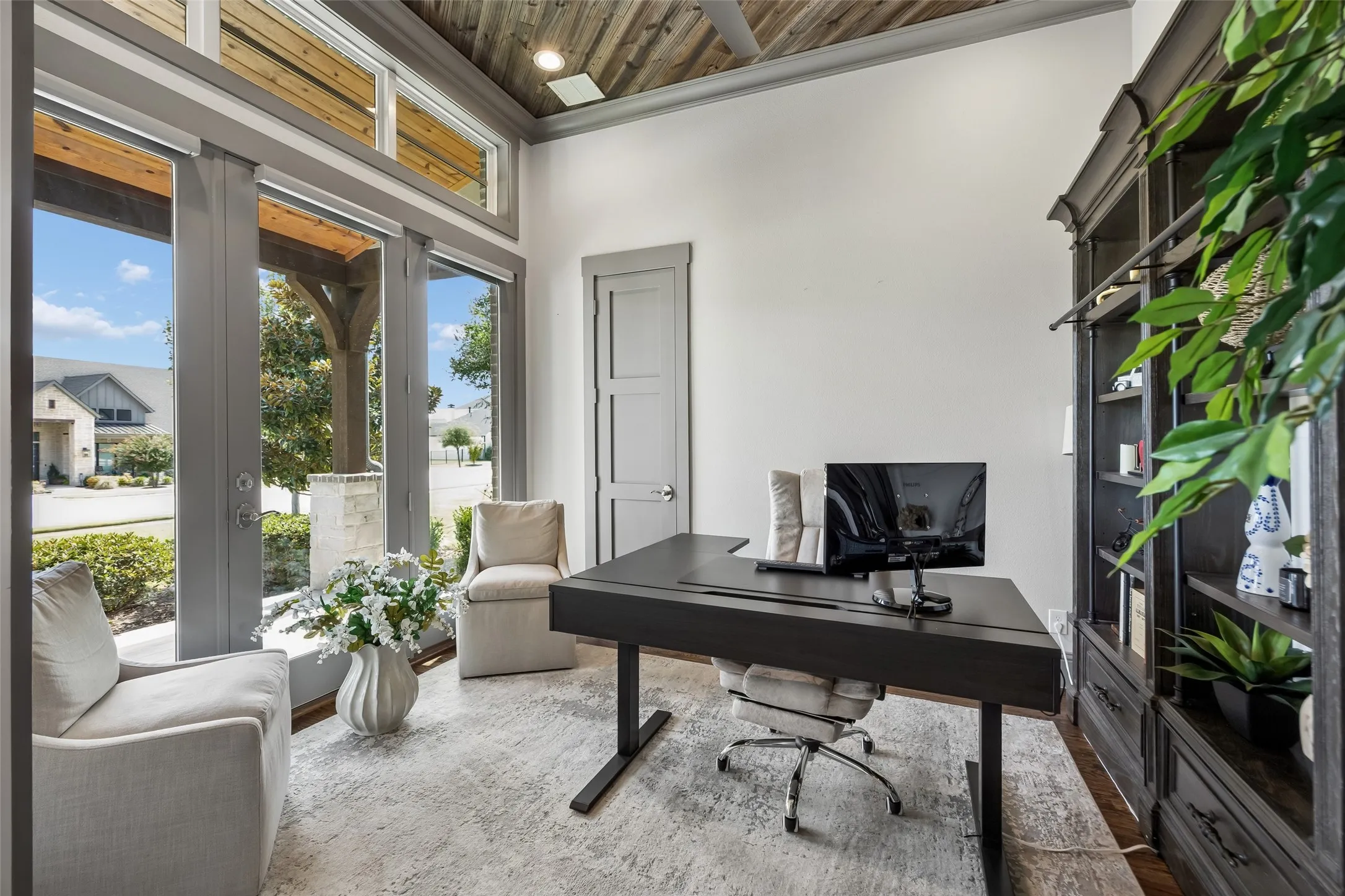 A Private Office with Architectural Character – Positioned just off the entry, the executive office features tall windows, abundant natural light, a wood-paneled ceiling, and barn-door access that provides privacy without closing the room off completely.