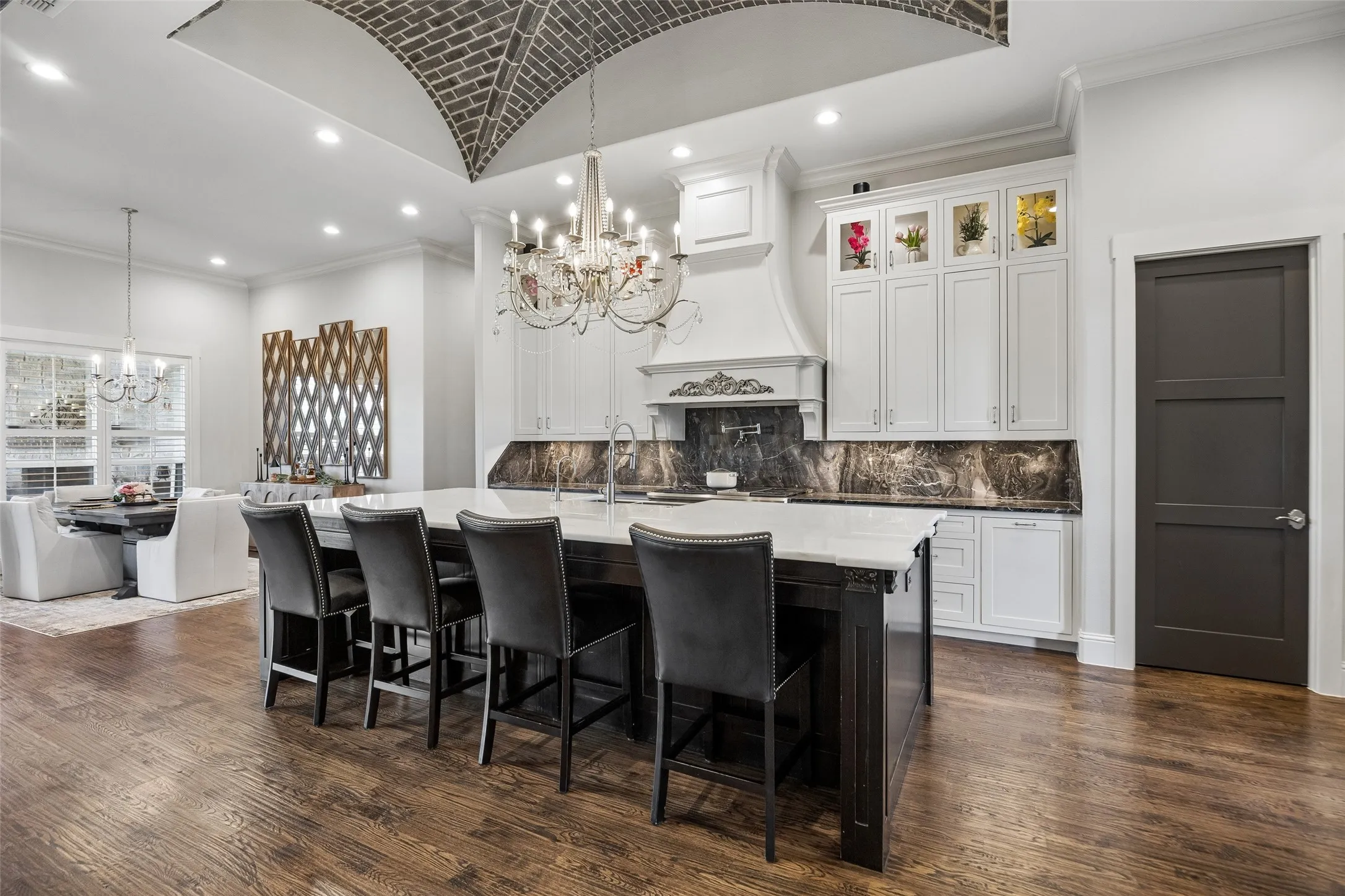 A Chef’s Kitchen That Commands Attention – The hand-laid brick vaulted ceiling, dramatic stone surfaces, floor-to-ceiling cabinetry, and oversized quartz island make this kitchen unforgettable. A professional GE Monogram appliance suite—including the 48-inch gas range and built-in refrigerator—delivers serious cooking power, while abundant seating and open sightlines make the space equally impressive for entertaining.