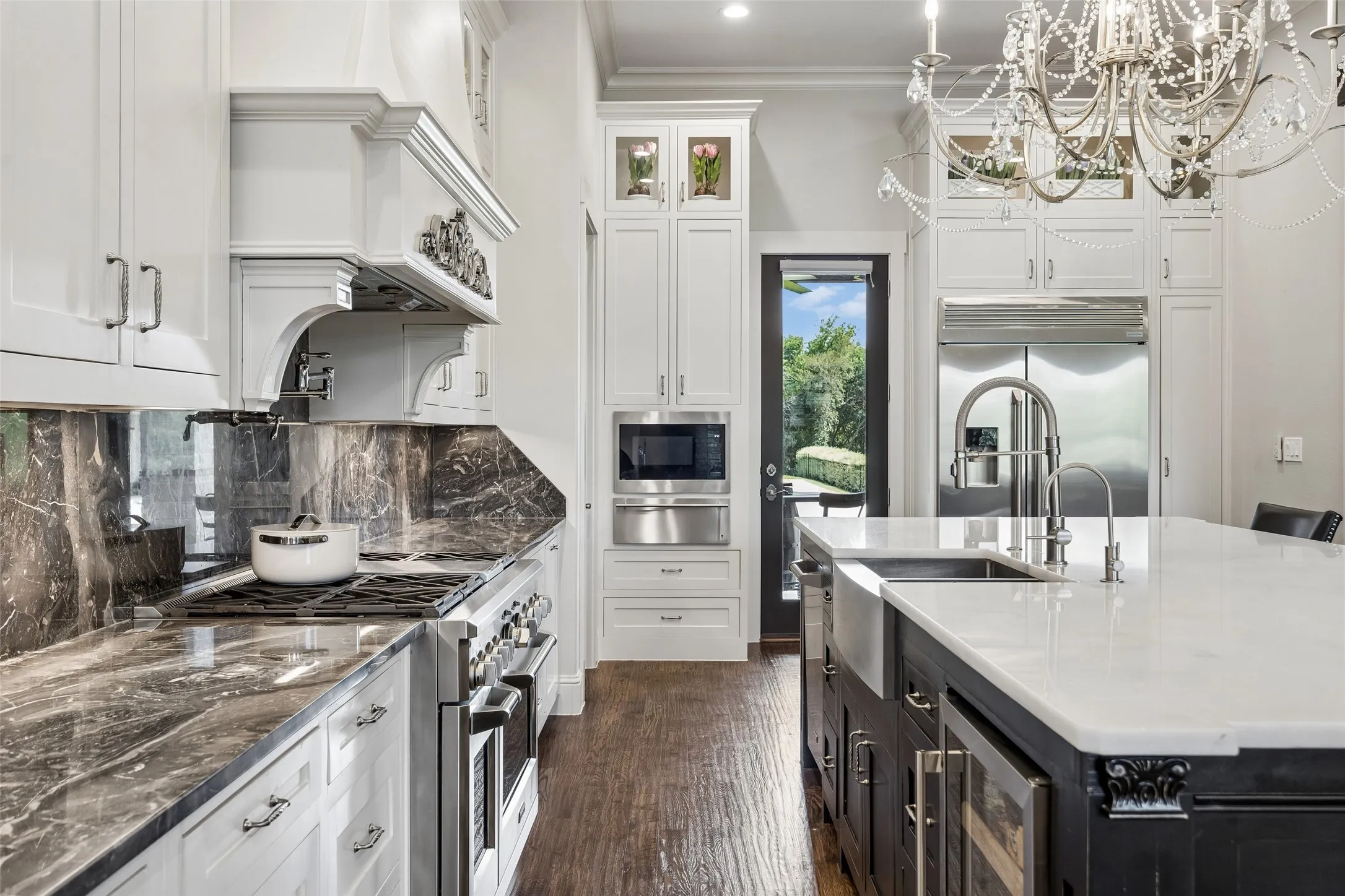 Custom Details Above and Around Every Work Zone – Floor-to-ceiling cabinetry, an architectural vent hood, illuminated stone backsplash, and the hand-laid brick ceiling give this kitchen a level of craftsmanship that stands apart from standard builder finishes.
