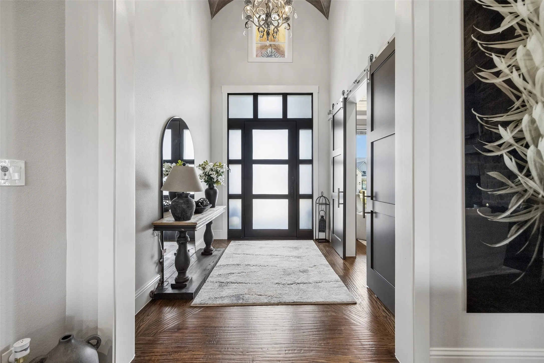 A Dramatic, Light-Filled Entry – A contemporary glass-paneled front door, soaring ceiling, statement lighting, and wide interior openings set the tone for the custom architectural details found throughout the home. And don't forget to look up!