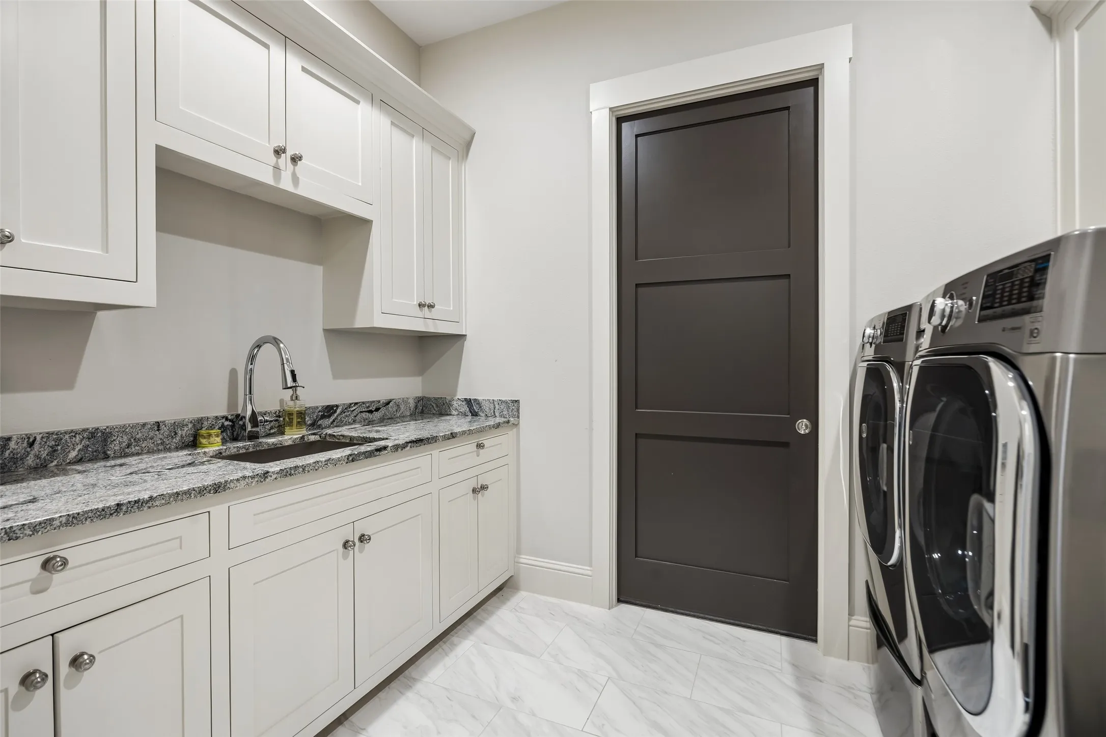 A Laundry Room Built for Everyday Efficiency – Generous cabinetry, an undermount utility sink, extensive granite counter space, and room for full-size appliances create a practical workspace for washing, folding, storage, and household organization.