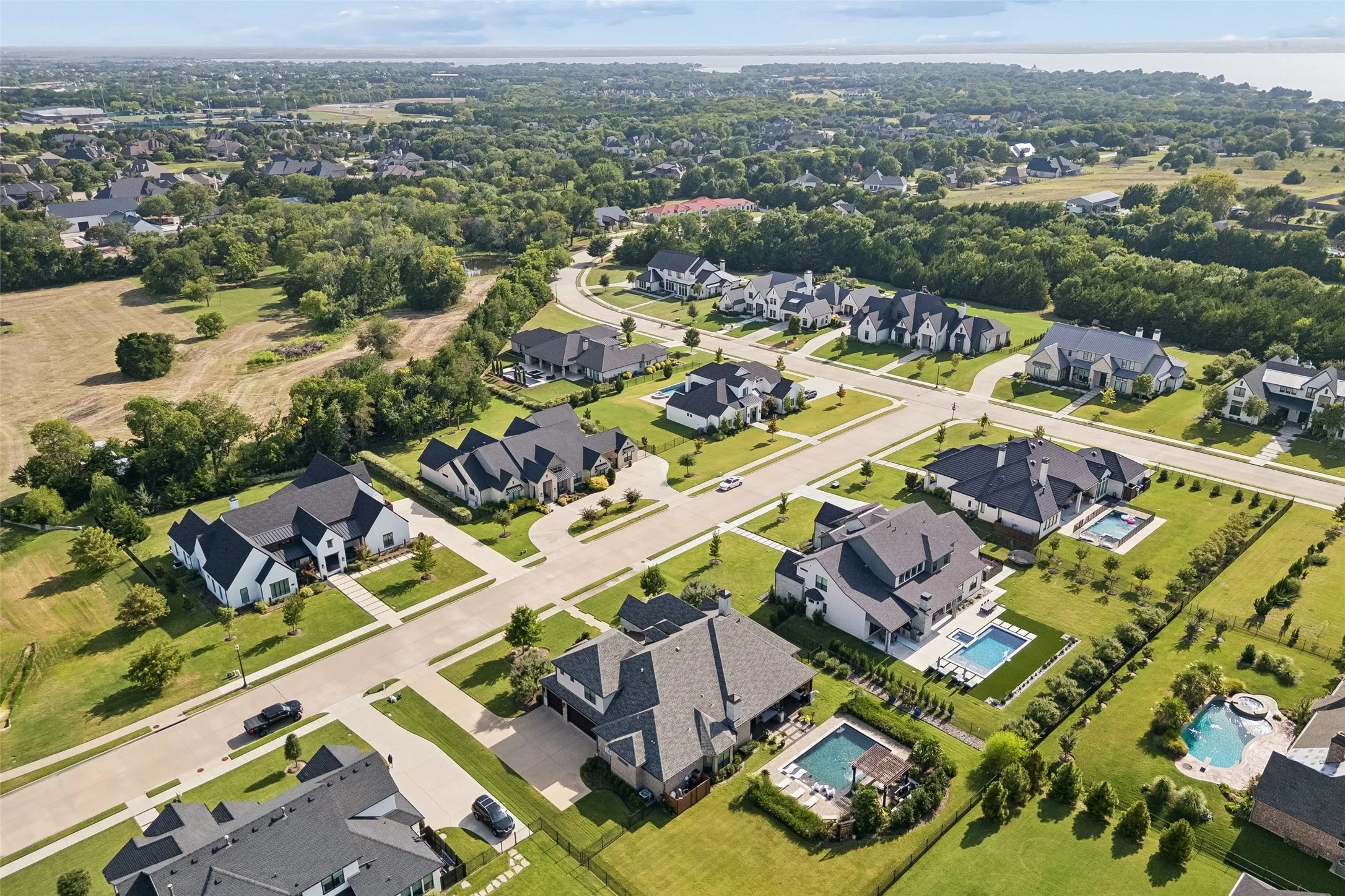 A Custom Home in an Established Heath Setting – The aerial perspective highlights the home’s architectural scale, landscaped grounds, side-entry drive, and position within The Renaissance.