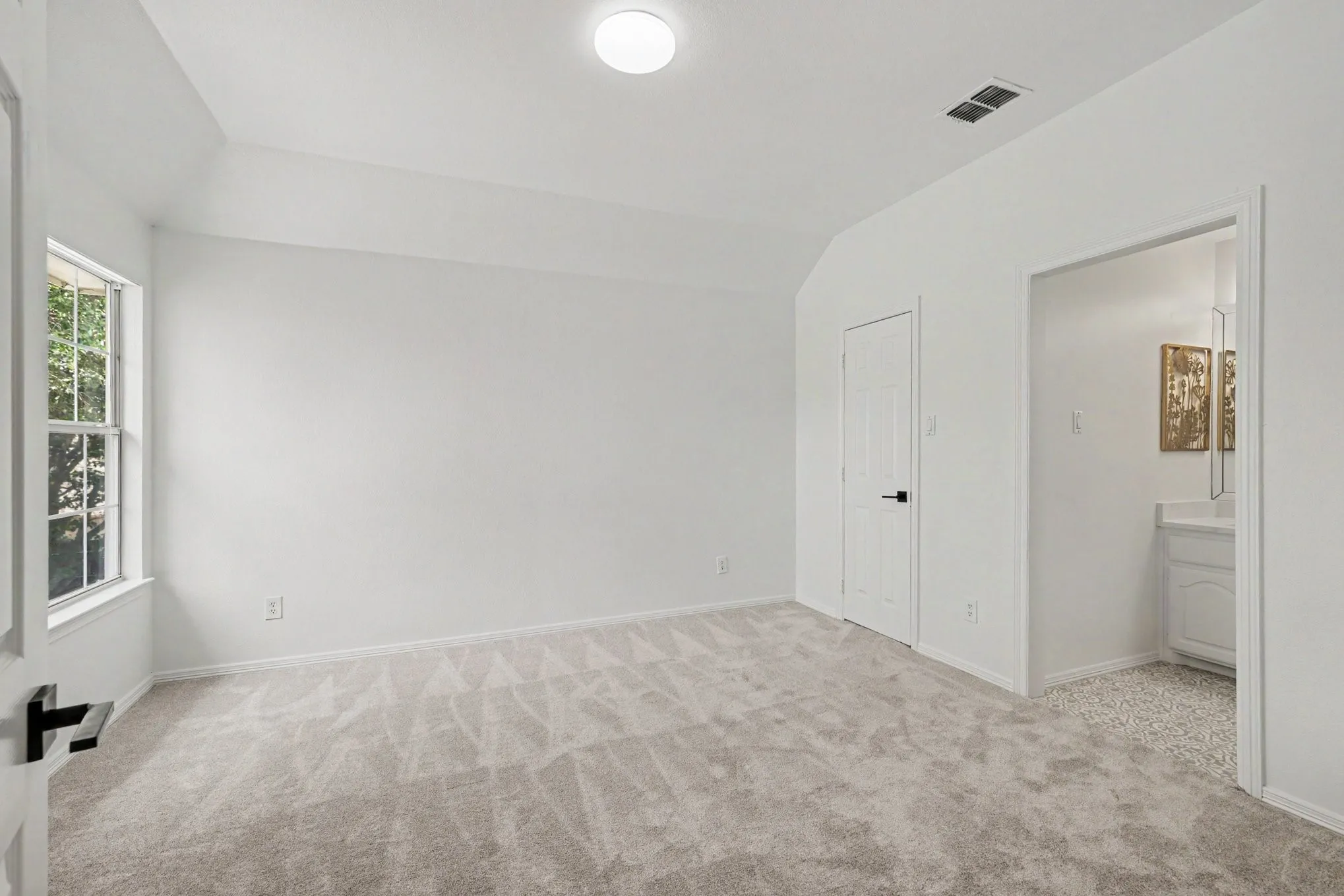 Carpeted room with a window, white walls, and a ceiling light
