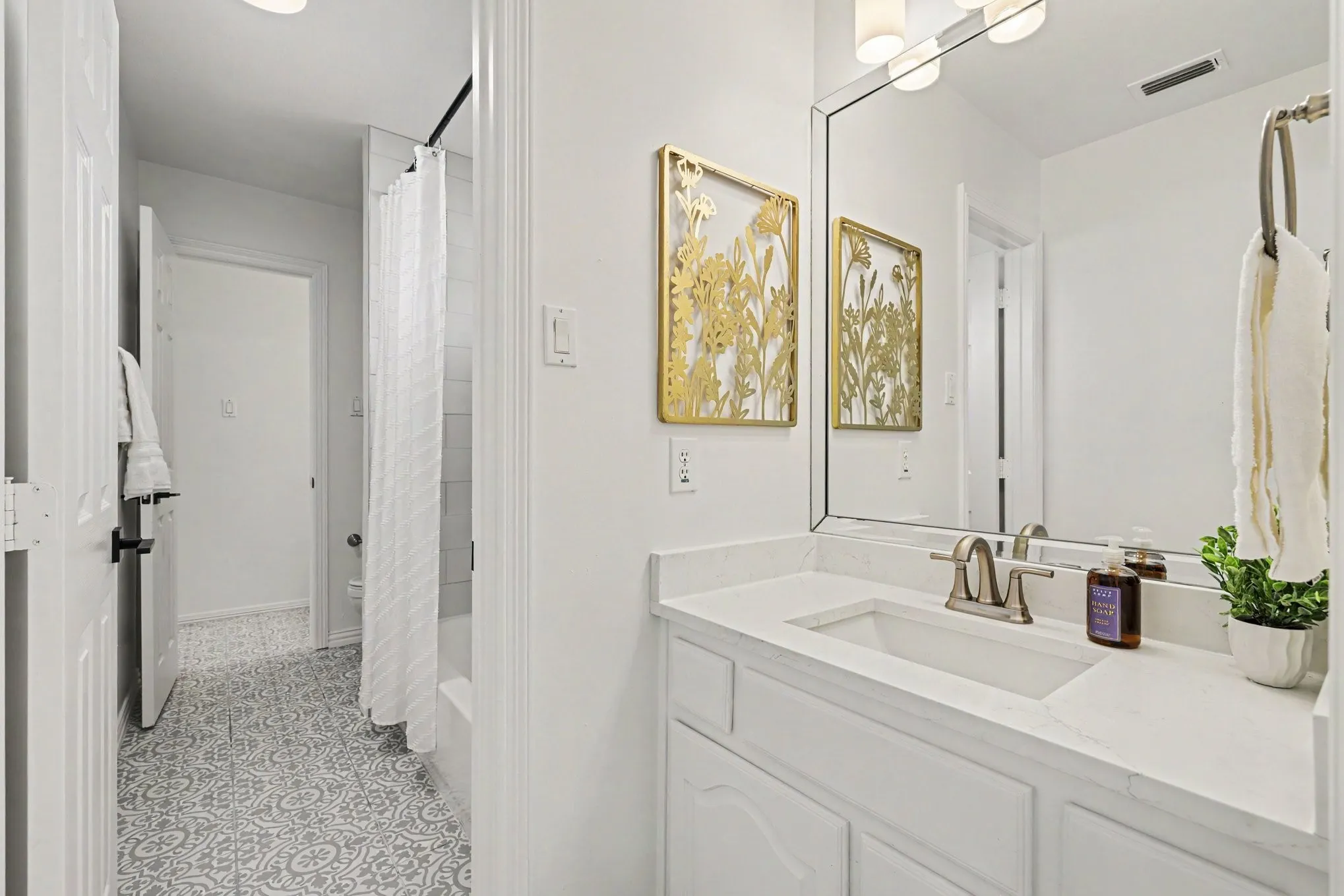 Bathroom featuring a single vanity with an integrated sink, polished chrome faucet, and white countertop