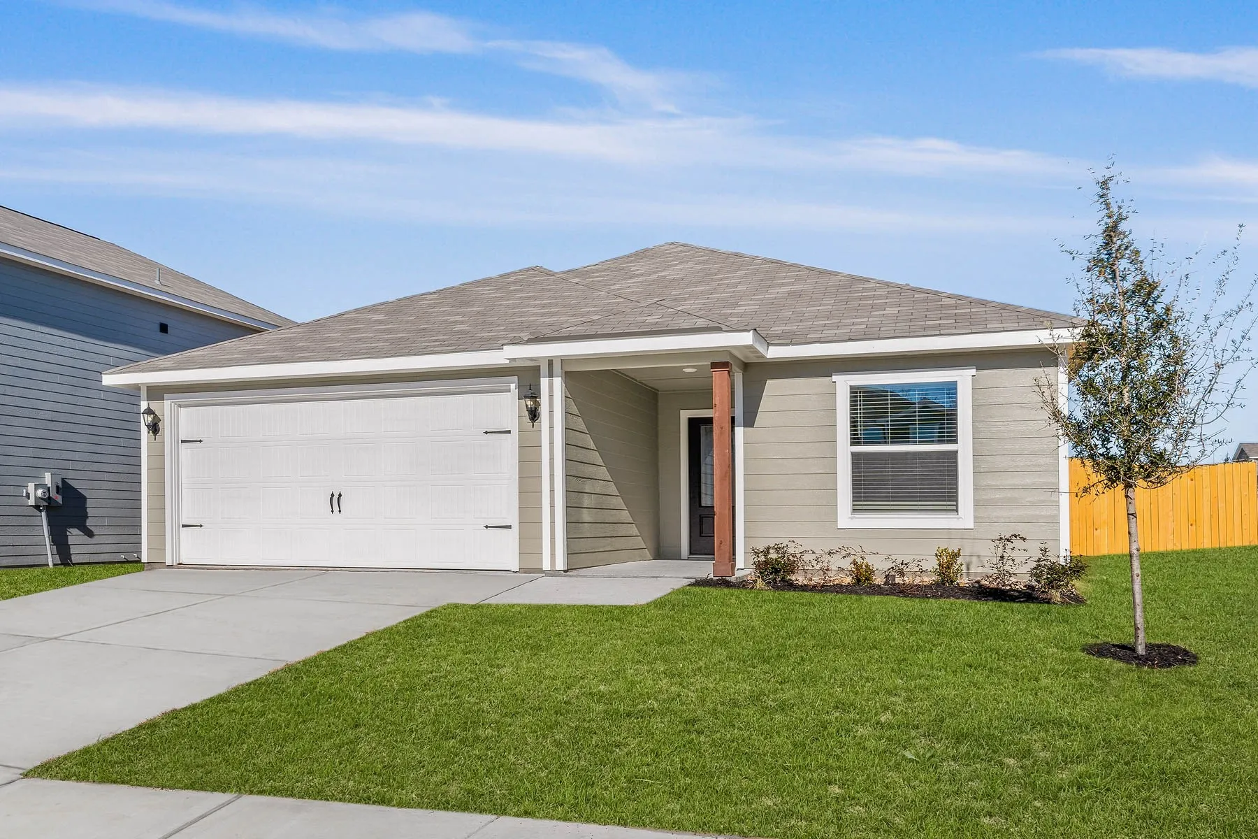Ranch-style house with a garage and a front lawn