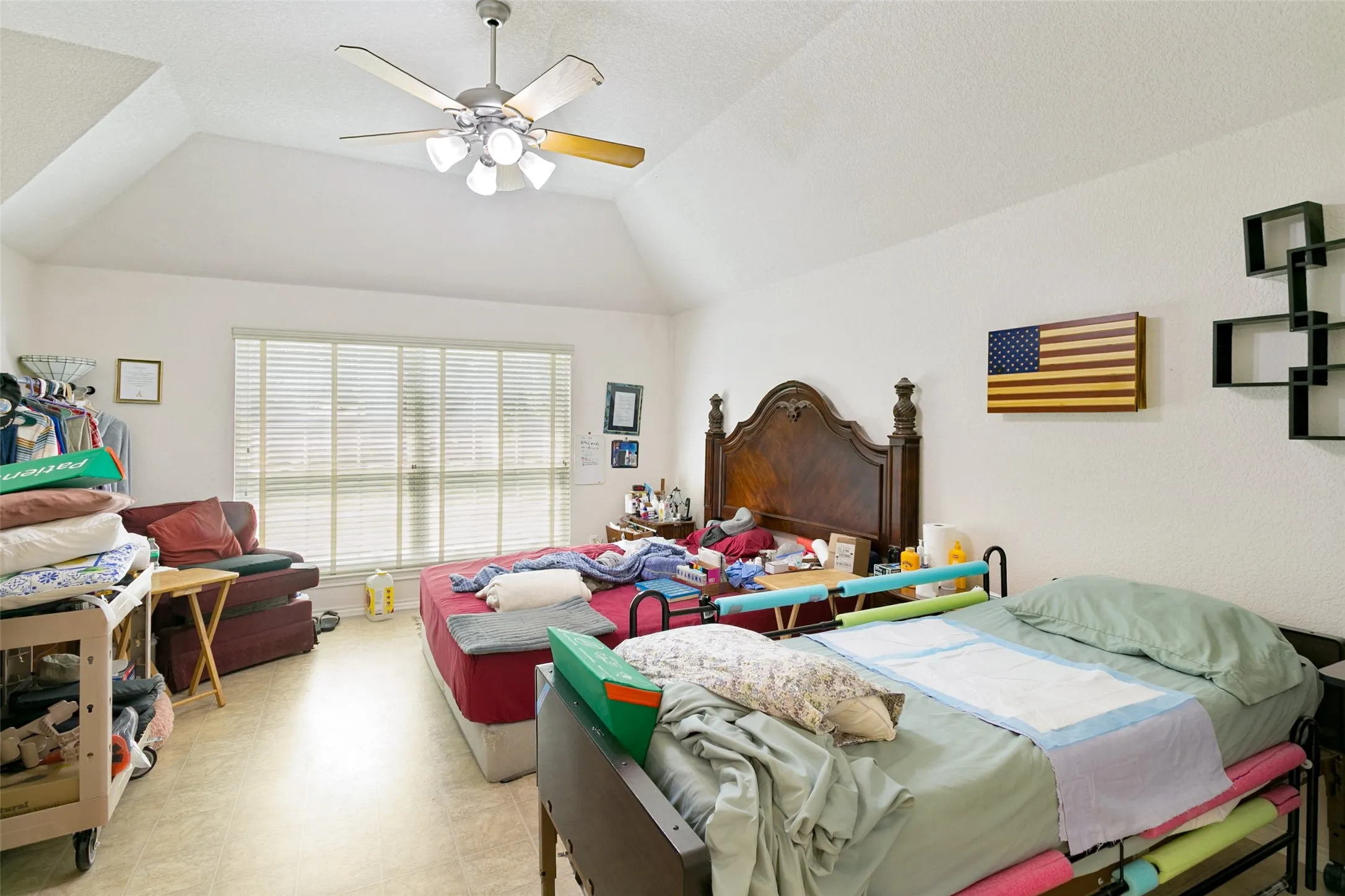 Spacious room with a vaulted ceiling and a ceiling fan with integrated lighting