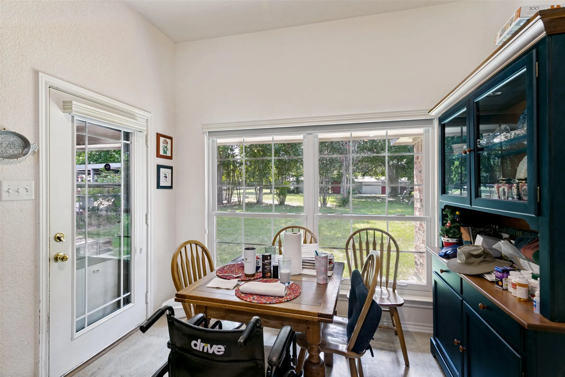 Dining area featuring a large window overlooking the exterior, a vaulted ceiling, and wood-finish flooring