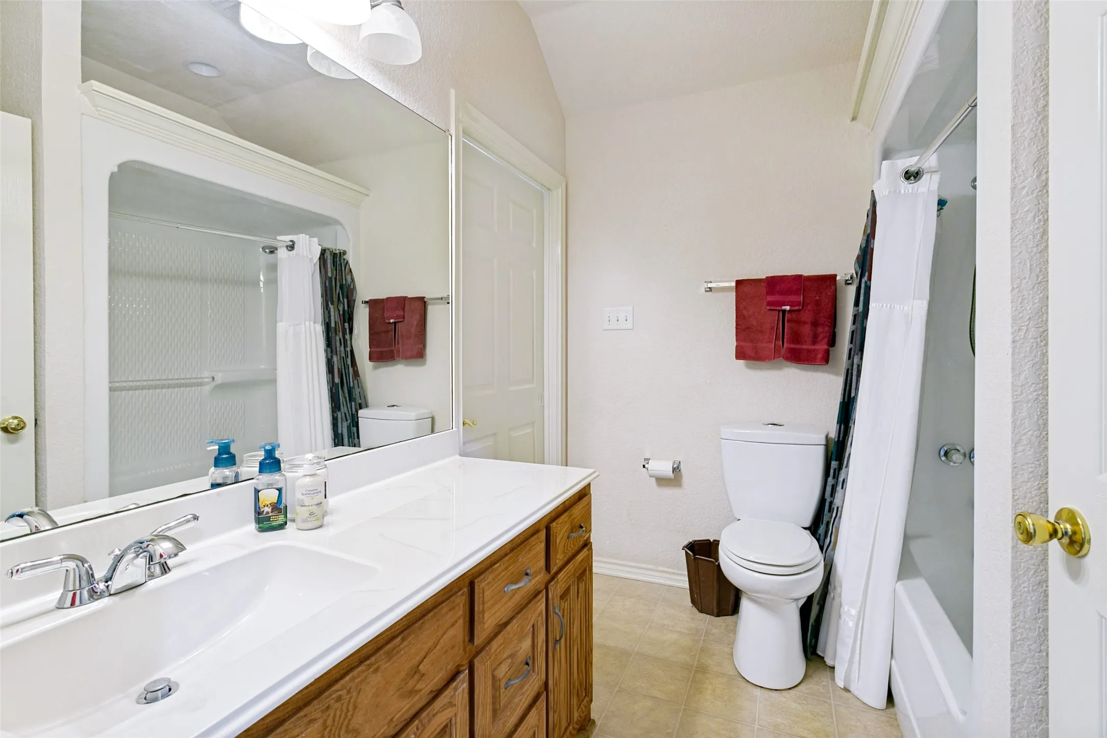 Bathroom vanity with an integrated sink, polished chrome faucet, and wood-finish cabinetry