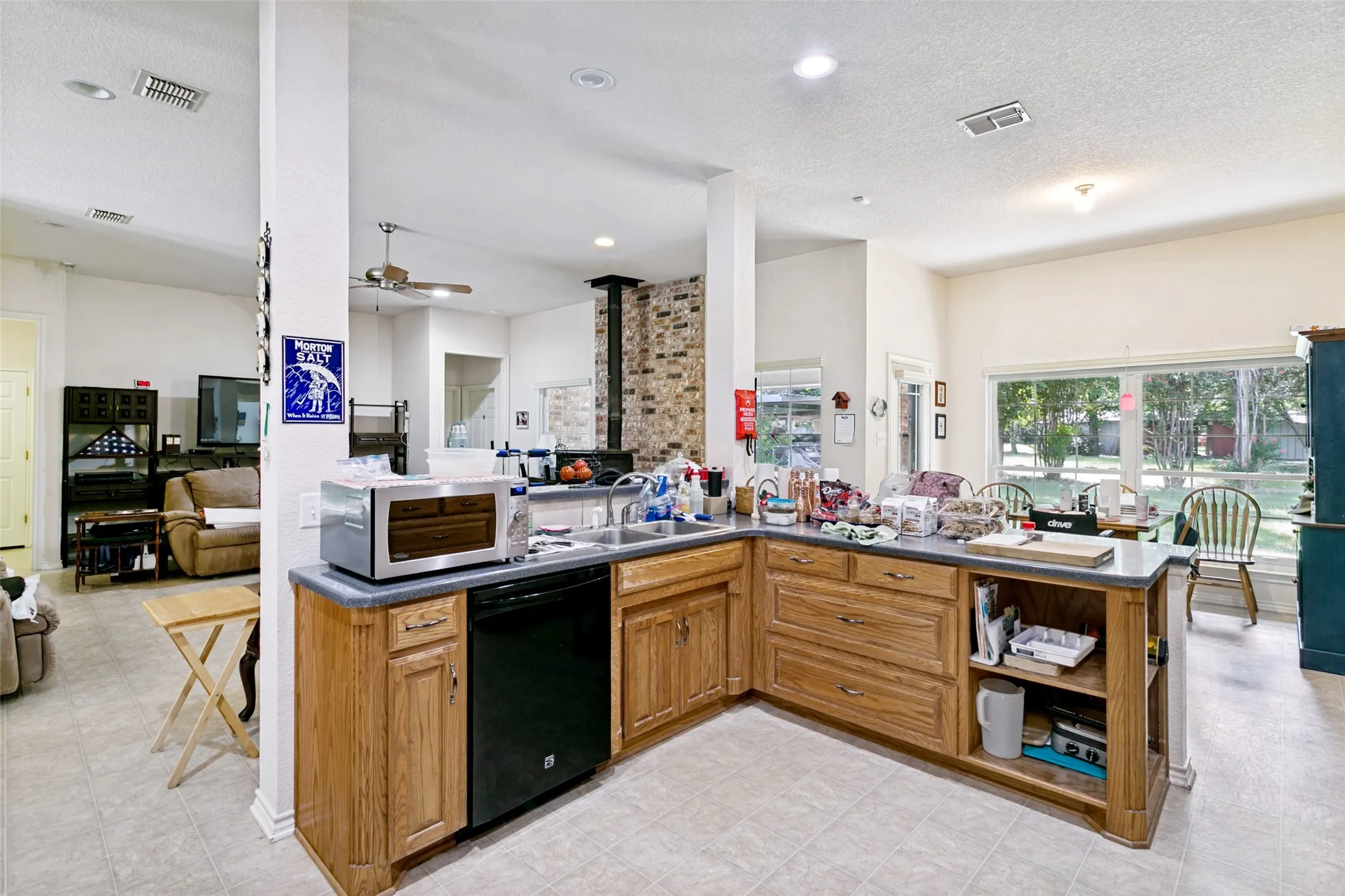 Kitchen featuring wood cabinetry, integrated dishwasher, and a double-basin sink