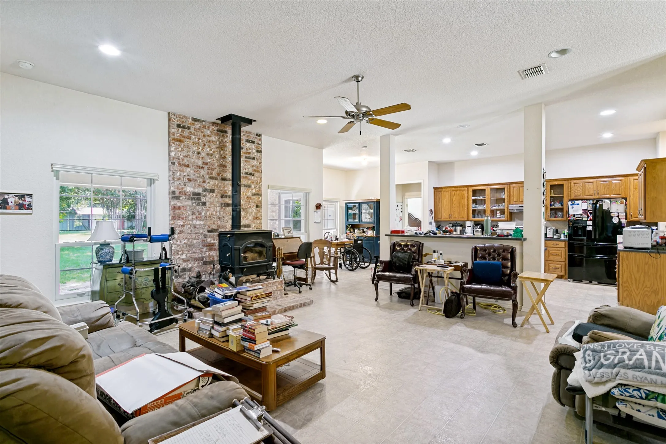 Expansive living area with a wood-burning stove and a ceiling fan