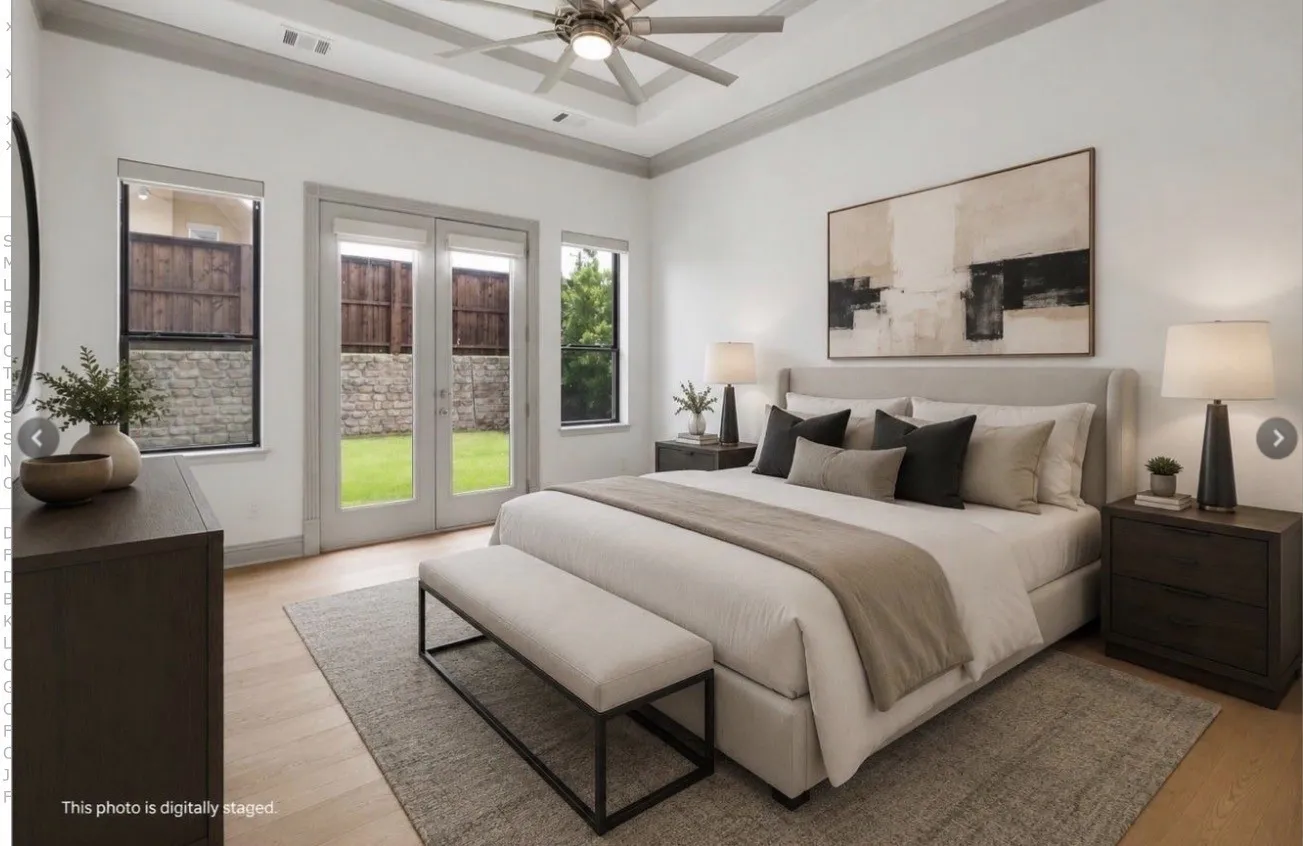 Virtually Staged - Spacious bedroom featuring light wood-finish flooring, a tray ceiling with a contemporary ceiling fan, and direct patio access through double glass doors