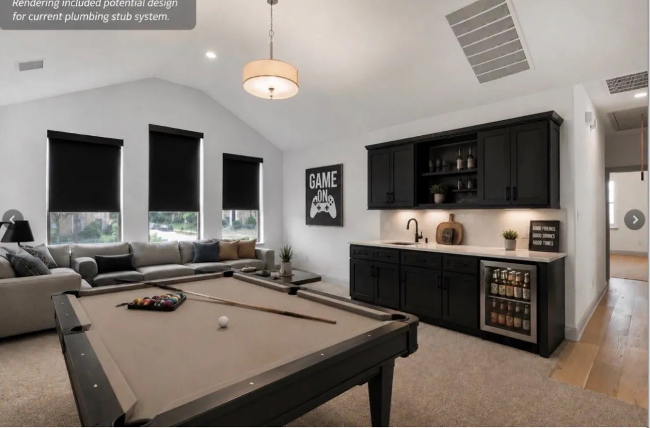 Virtually Staged - Vaulted ceiling accentuates this versatile space featuring a plumbed in area that can have a built-in wet  bar added at the buyer's expense.cabinetry, integrated beverage refrigerator, sink, and upper display shelving