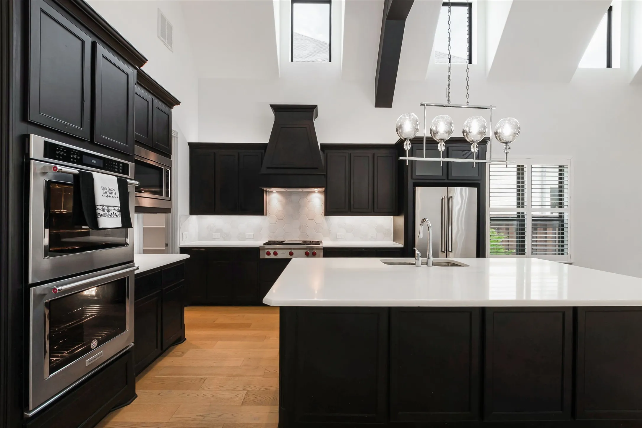 Kitchen featuring dark wood cabinetry, ight LVP flooring, and white countertops