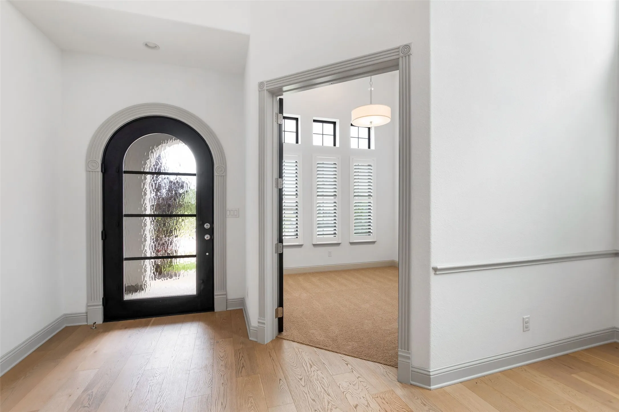 Arched entry door with reeded glass panels and black frame
