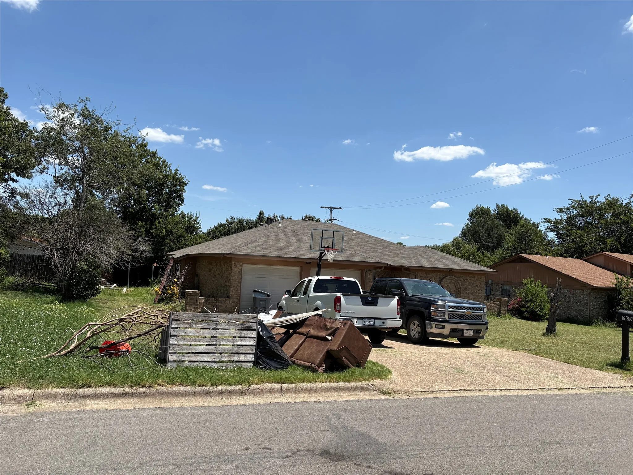 Brick exterior home featuring an attached two-car garage, a concrete driveway, and a sloped roof