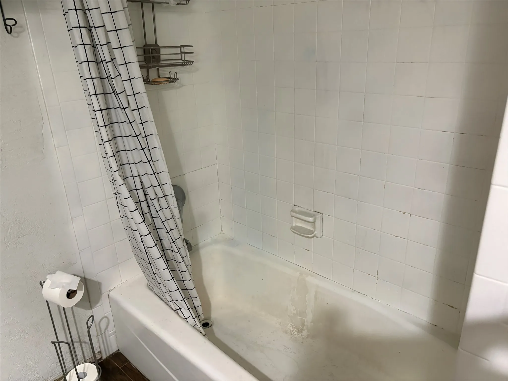 White tiled shower surround with a built-in soap dish