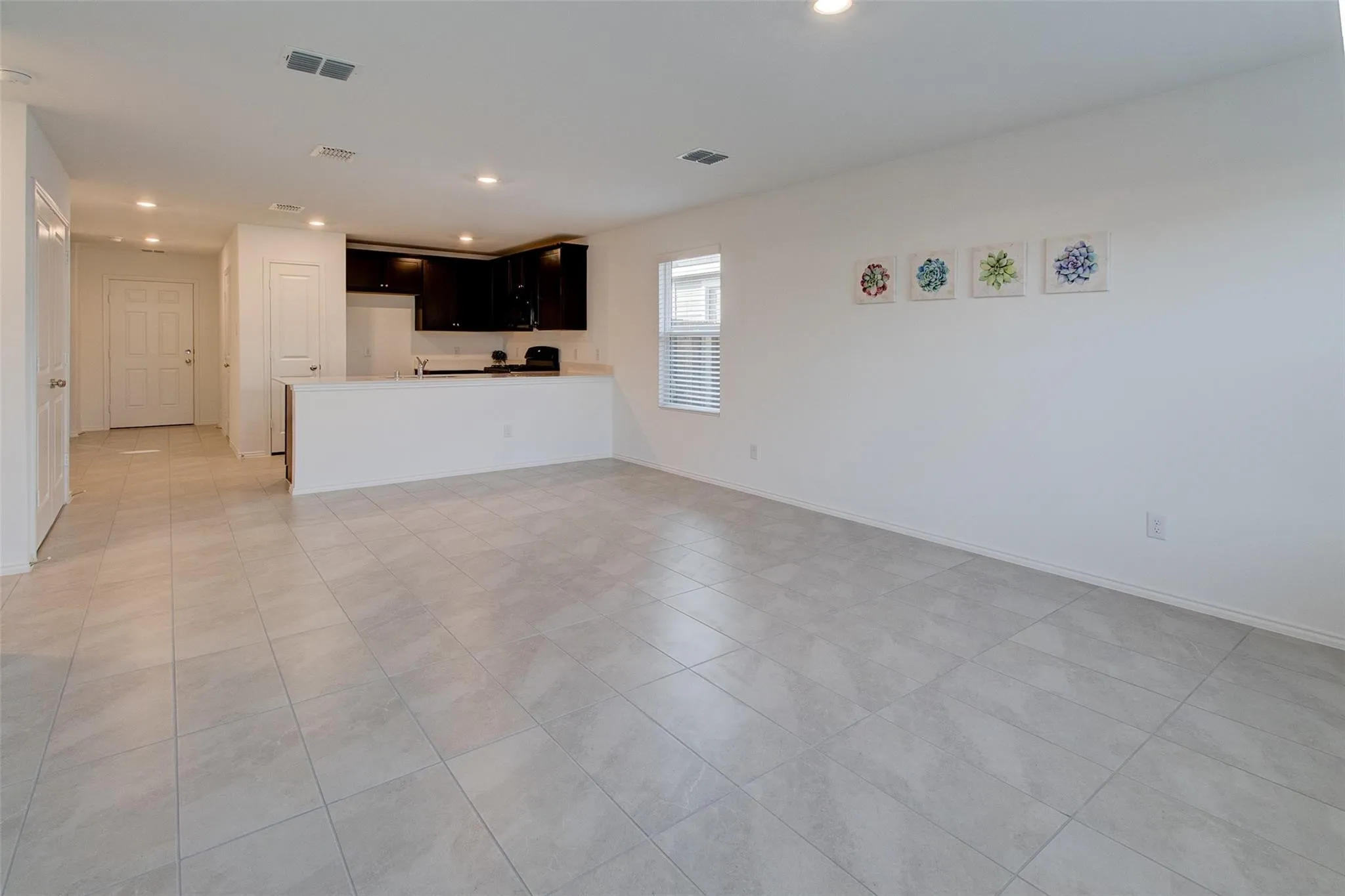 Spacious living area featuring light-toned tile flooring throughout