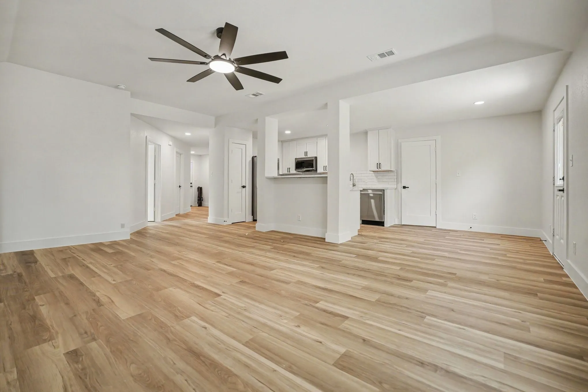 Open-concept living area featuring wood-finish flooring, recessed lighting, and a contemporary ceiling fan
