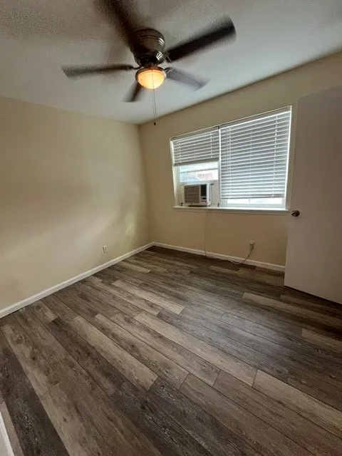 Wood-finish flooring, ceiling fan with integrated lighting, and window with blinds